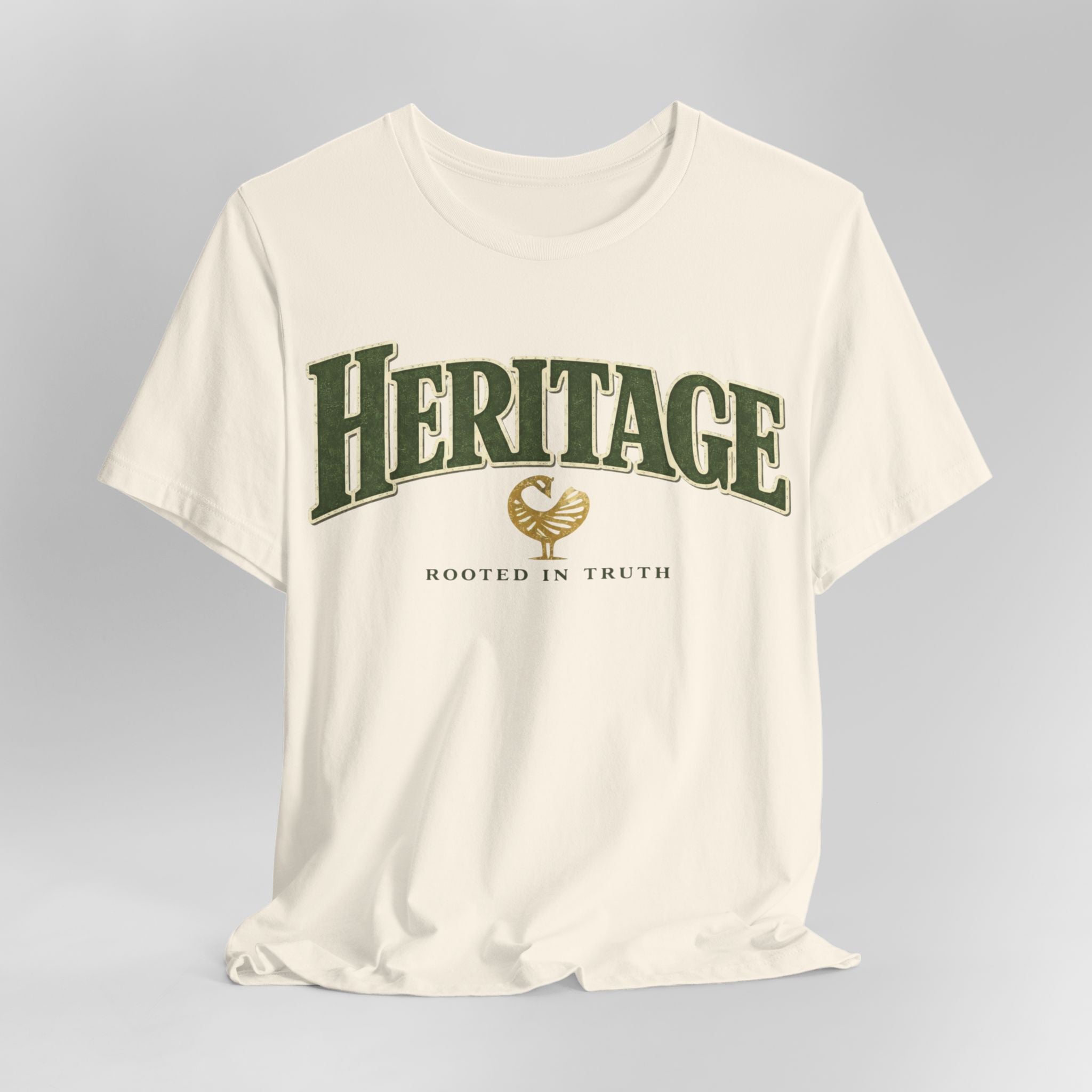 White t-shirt with 'Heritage Rooted in Truth' text and logo on a gray background