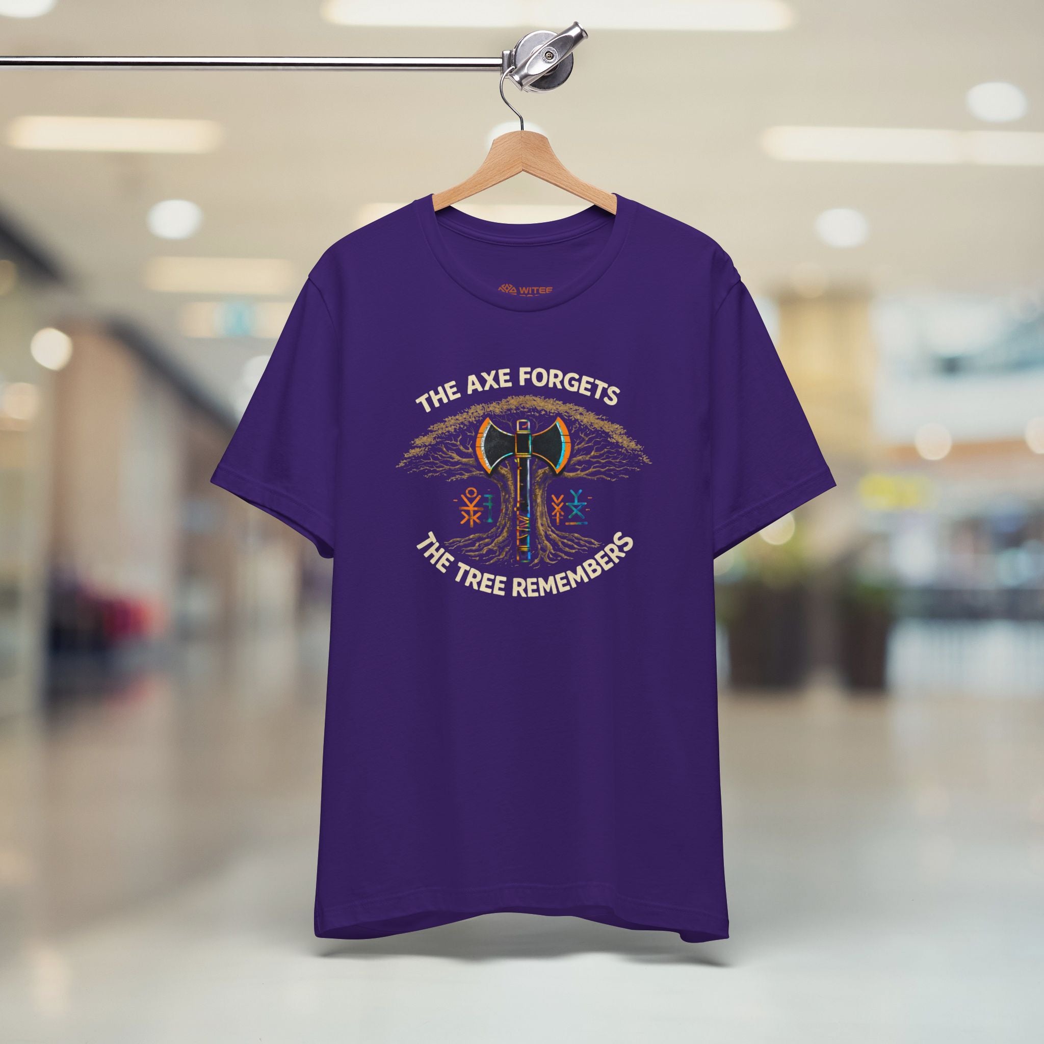 Purple t-shirt with graphic design and text on a hanger in a store setting
