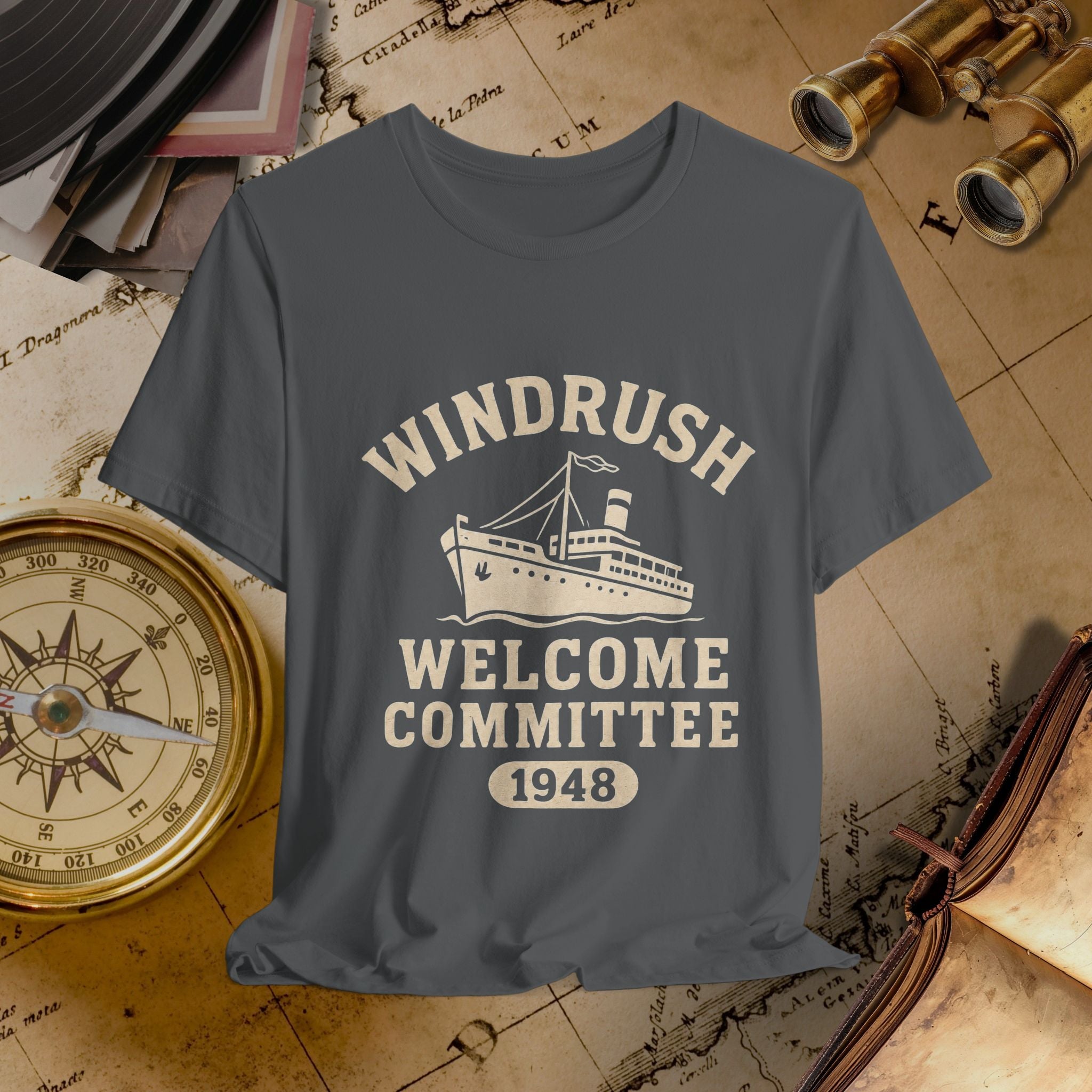 Gray t-shirt with 'Windrush Welcome Committee 1948' design on a vintage map background
