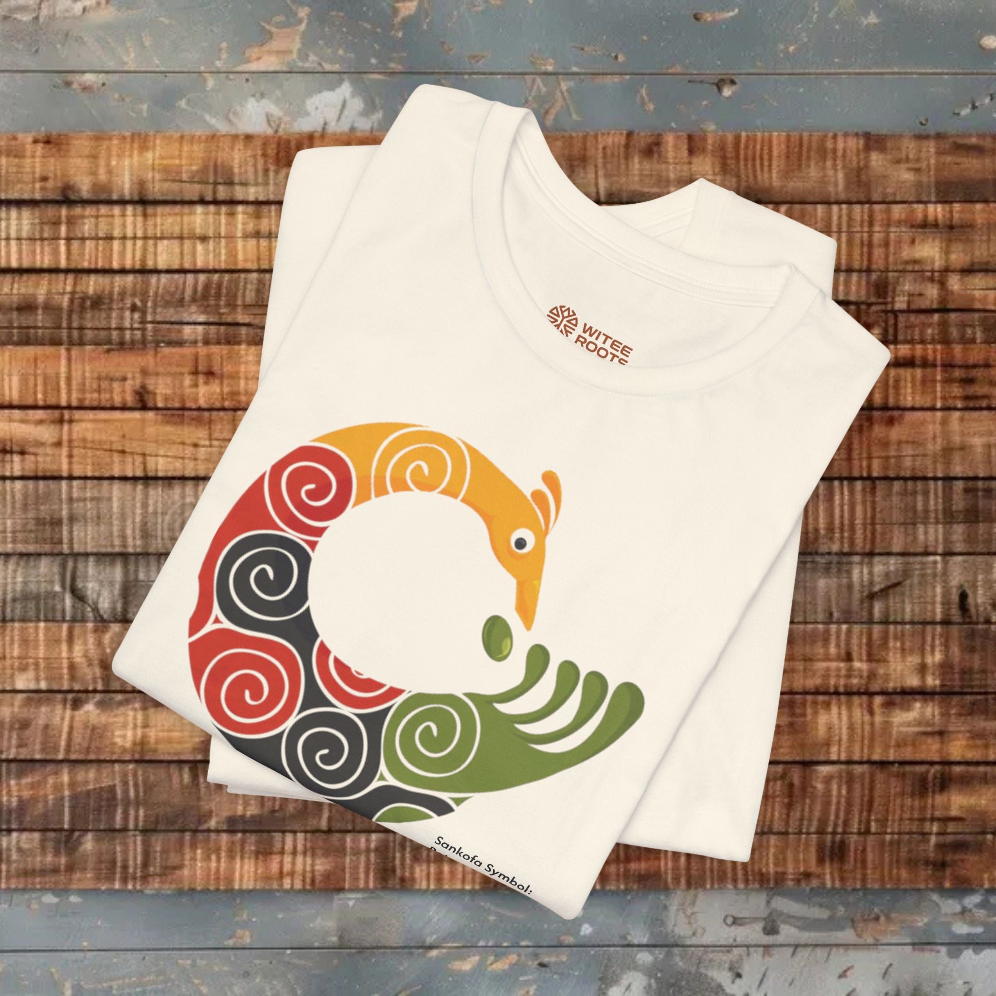 Beige t-shirt with colorful graphic design on a wooden surface
