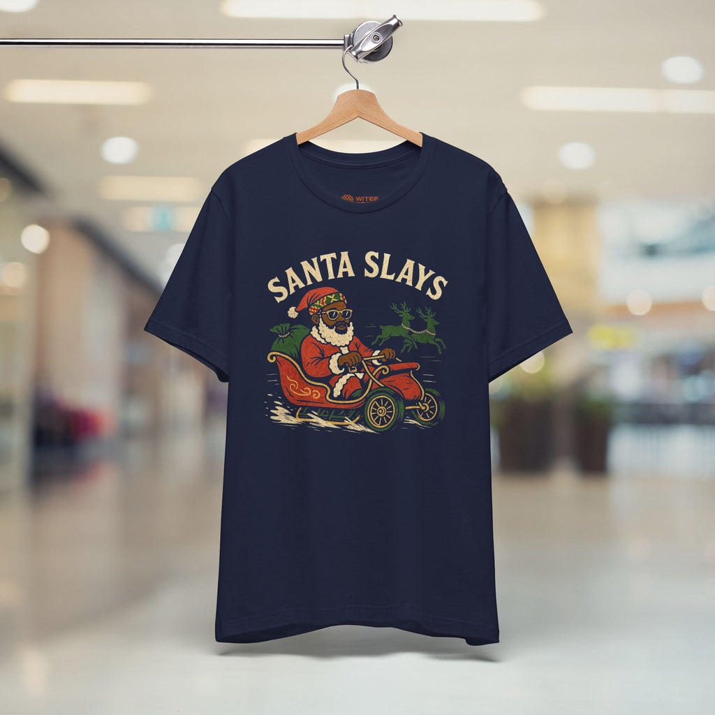 Navy blue t-shirt with 'Santa Slays' graphic on a hanger in a store.