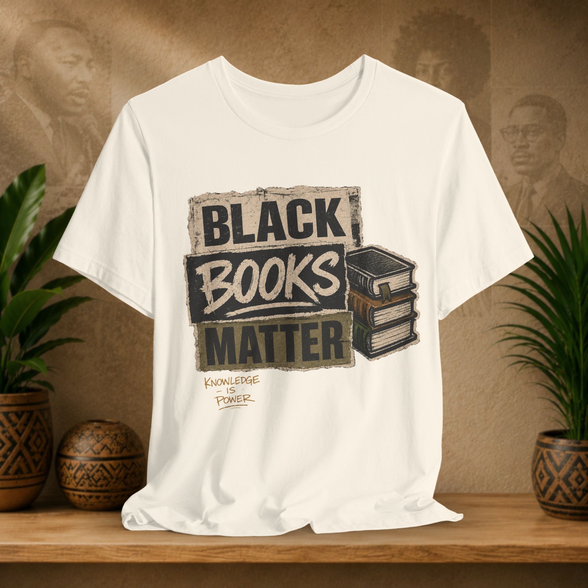 Bige t-shirt with 'Black Books Matter' graphic on a wooden shelf with plants and a textured wall background.