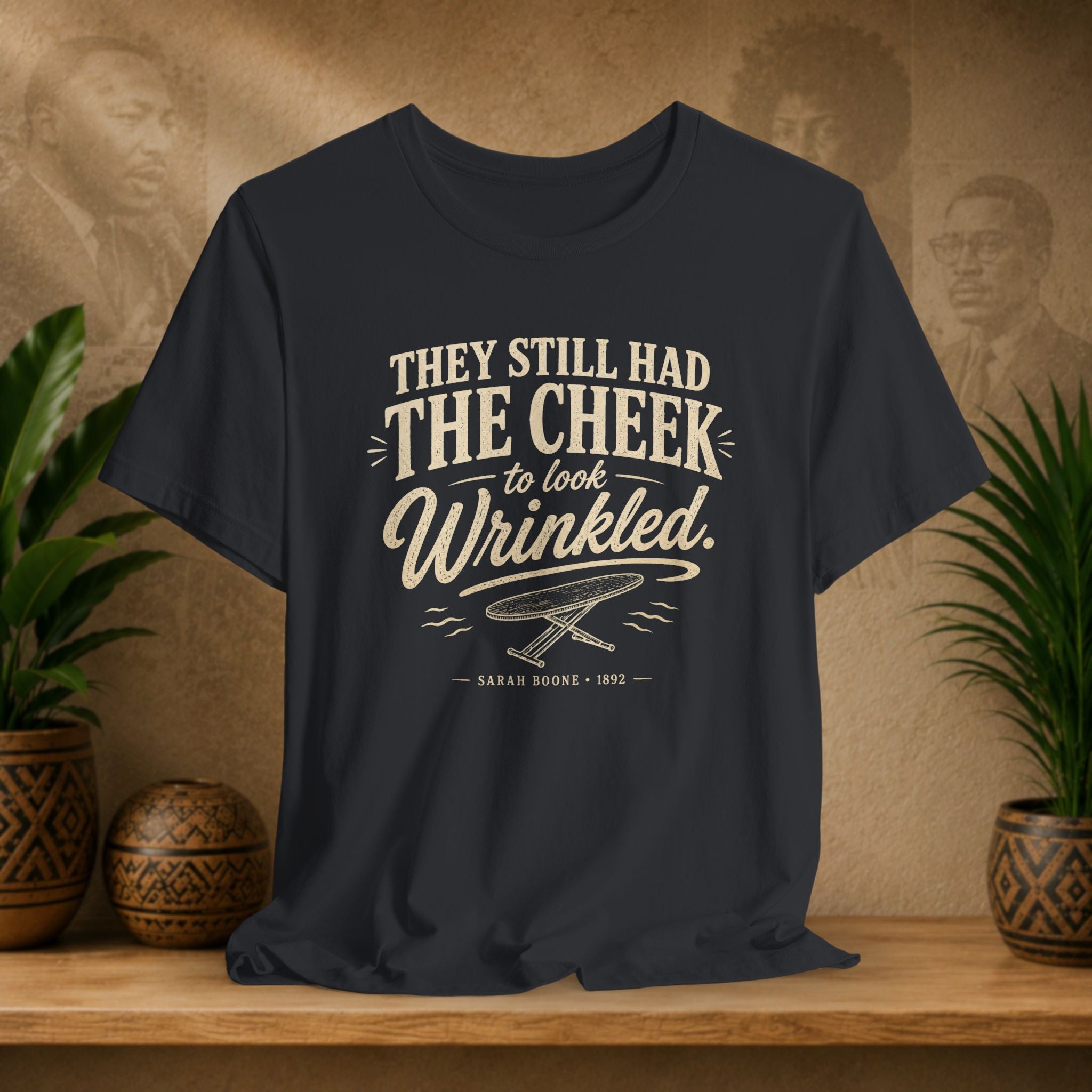 Navy t-shirt with text on a wooden surface with plants and a vintage-style background