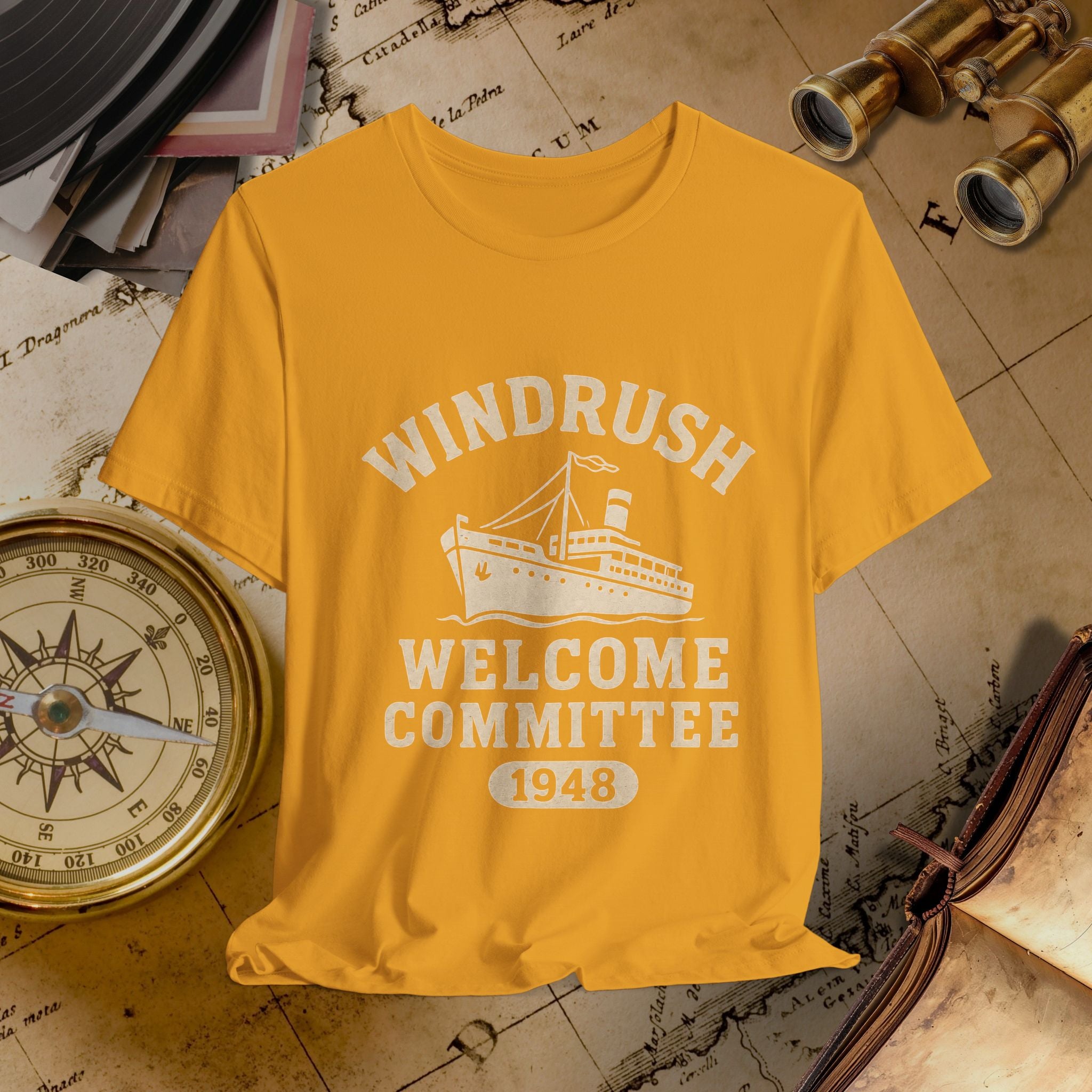 Yellow t-shirt with 'Windrush Welcome Committee 1948' design on a vintage map background.