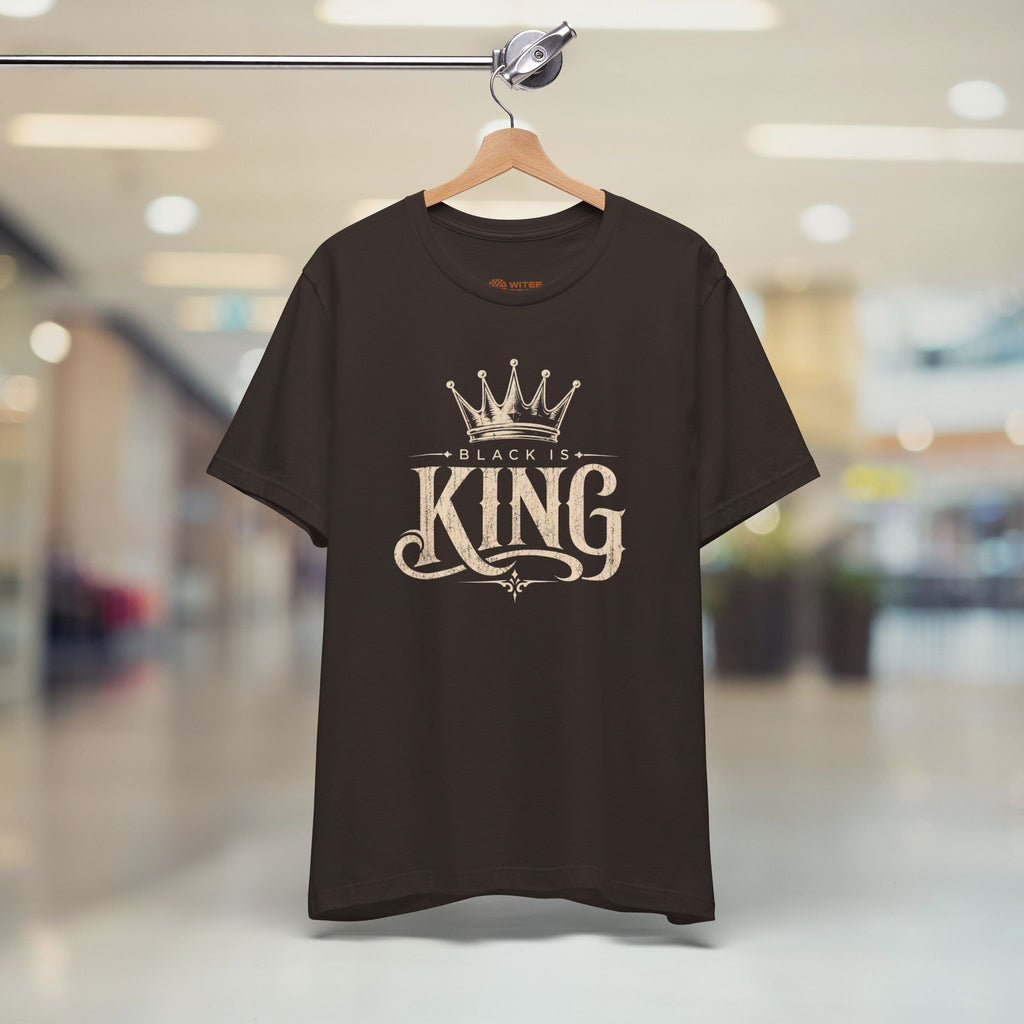 Brown t-shirt with 'Black is King' text on a hanger in a store setting