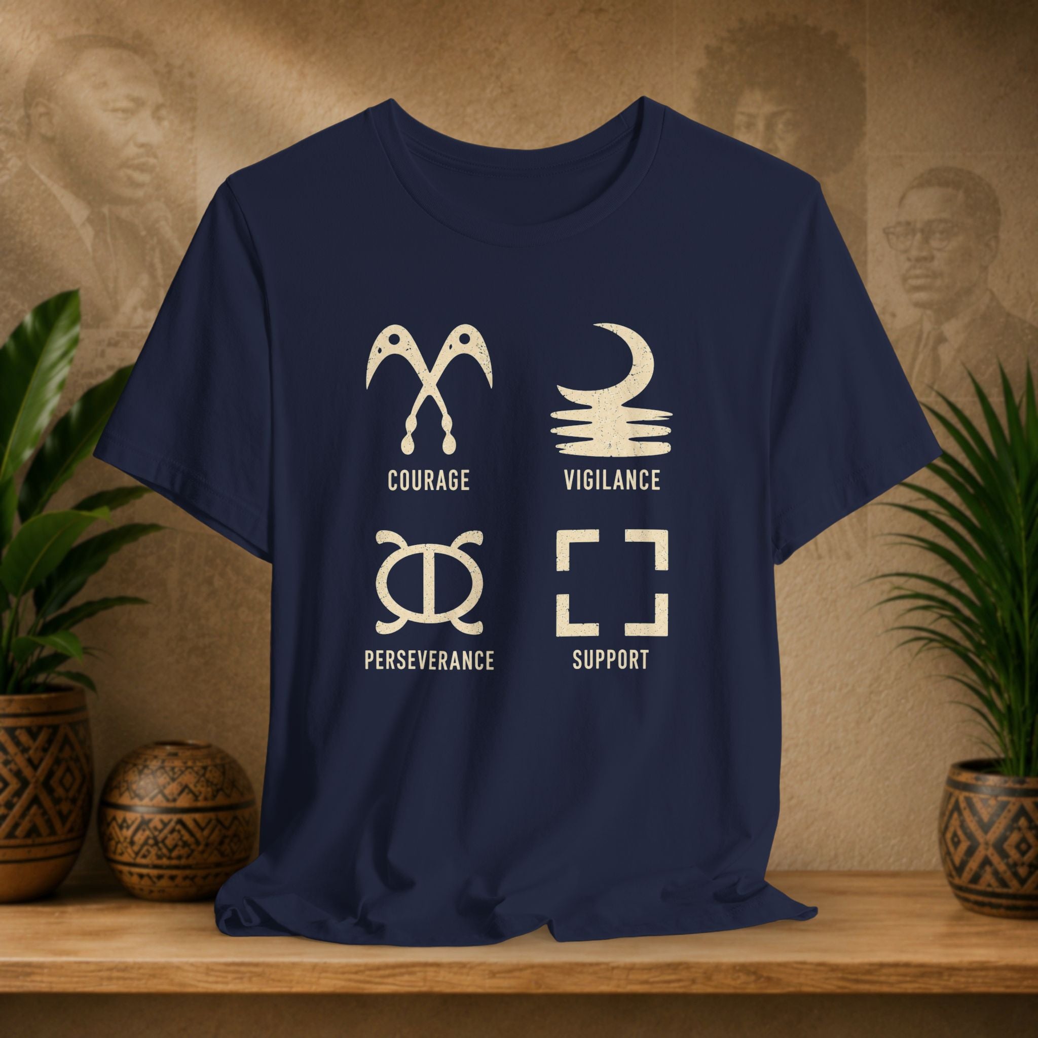 Navy blue t-shirt with white symbols and text on a wooden surface with decorative plants and background.
