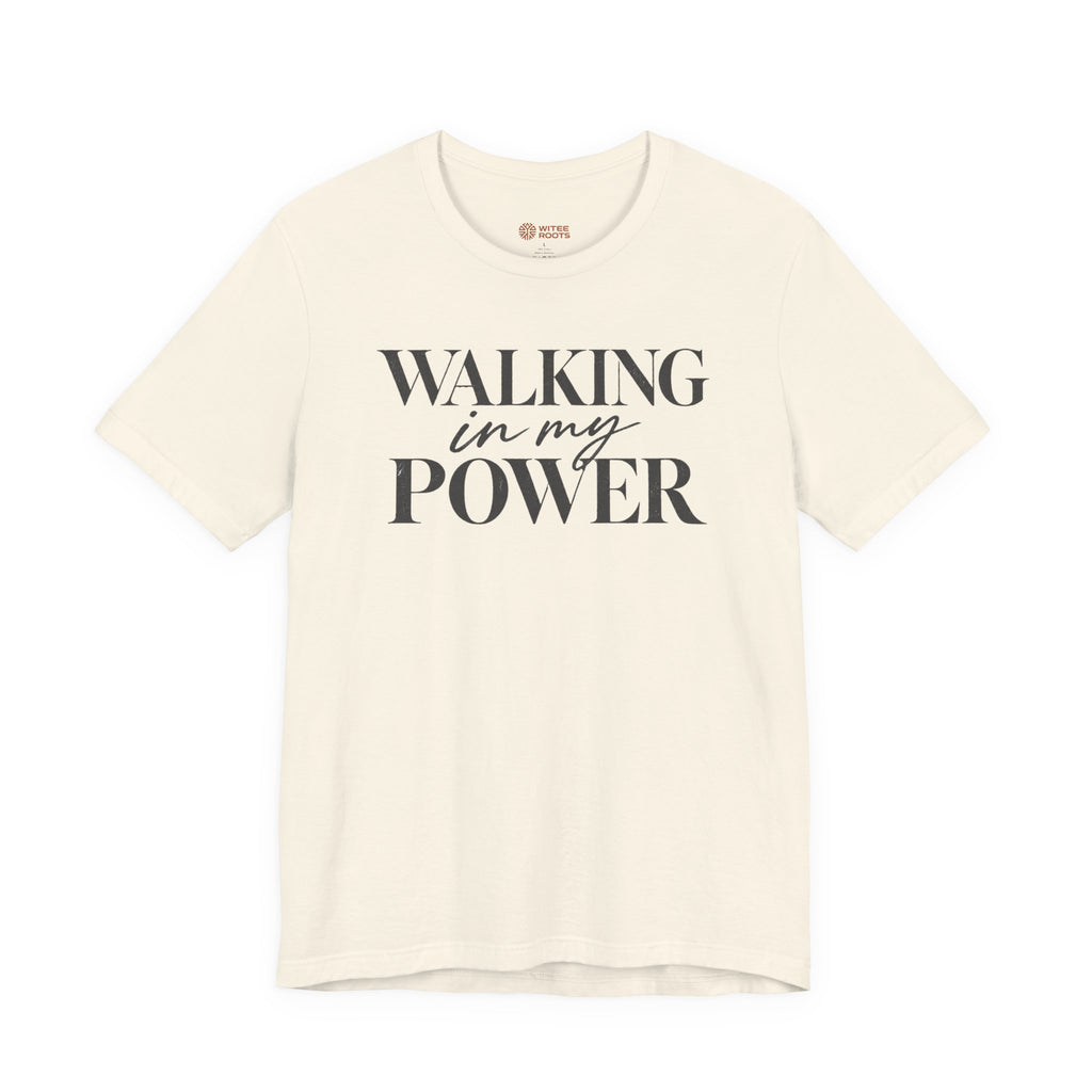 An off-white short-sleeve t-shirt with the text 'WALKING in my POWER' printed in dark gray on the front, displayed against a solid white background.