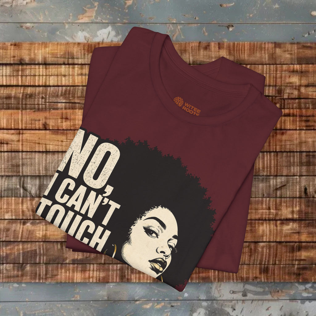 Folded t-shirt with graphic design and text on a wooden surface