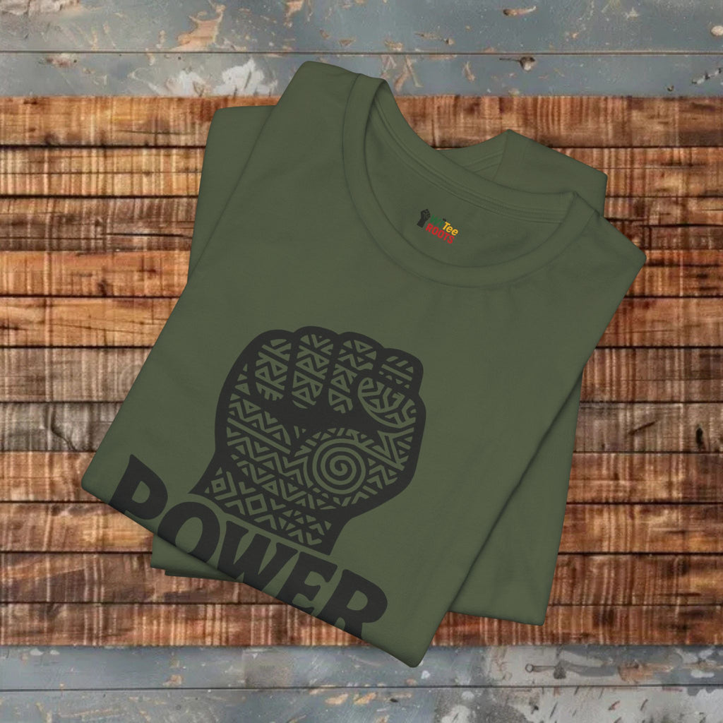 Green t-shirt with a black fist graphic and 'POWER' text on a wooden surface