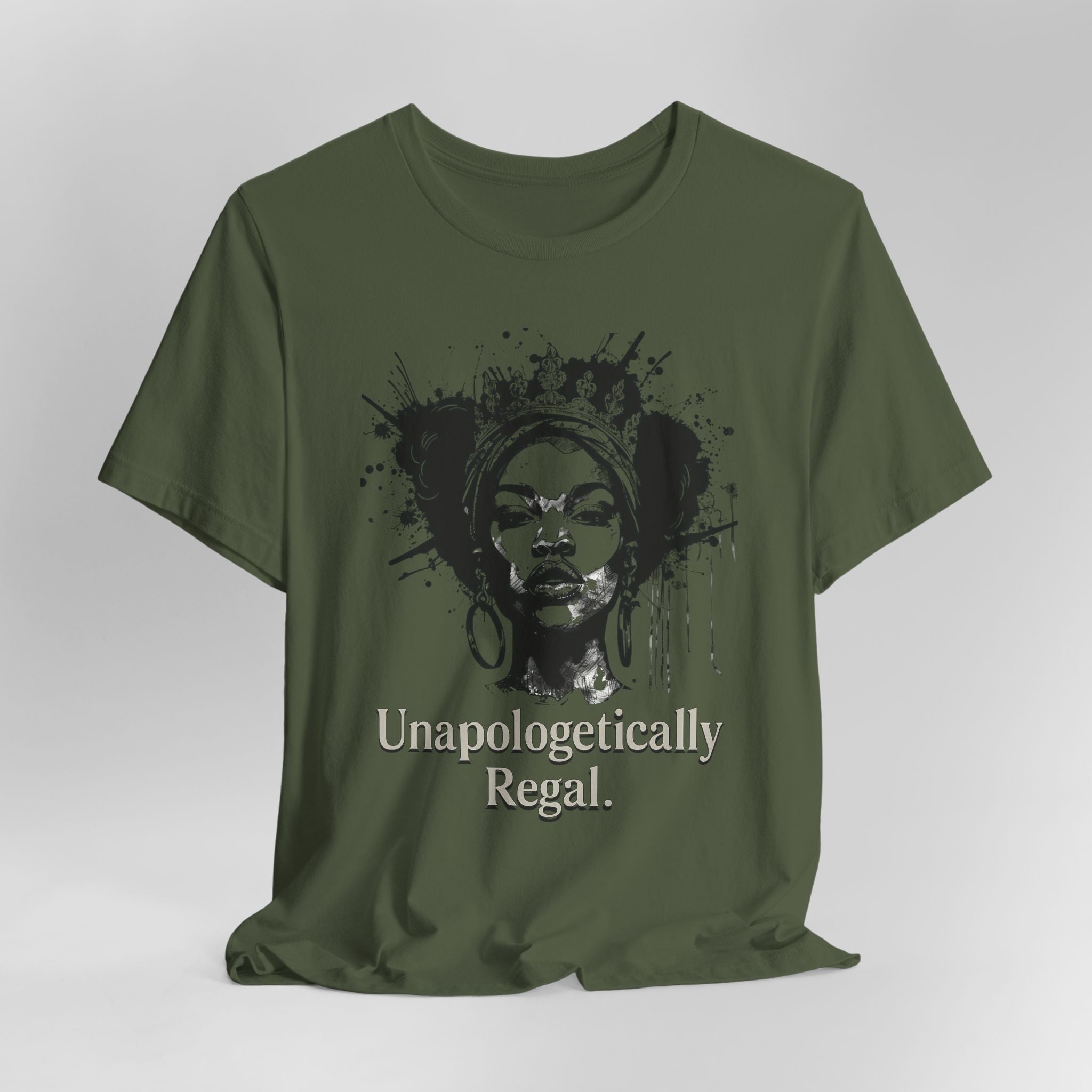 Green t-shirt with a graphic of a woman's face and the text 'Unapologetically Regal' on a white background.