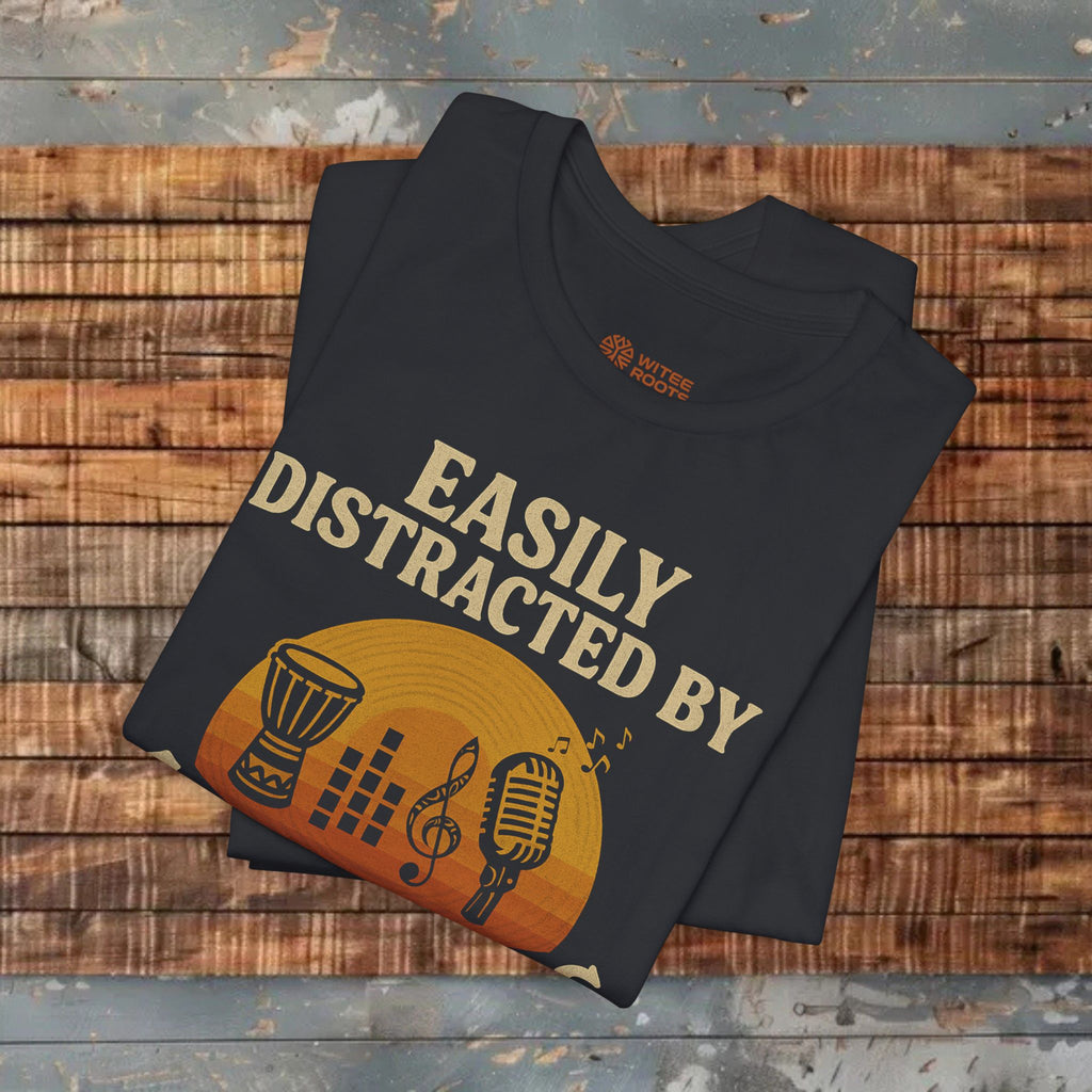 Folded black t-shirt with music-themed design on a wooden surface