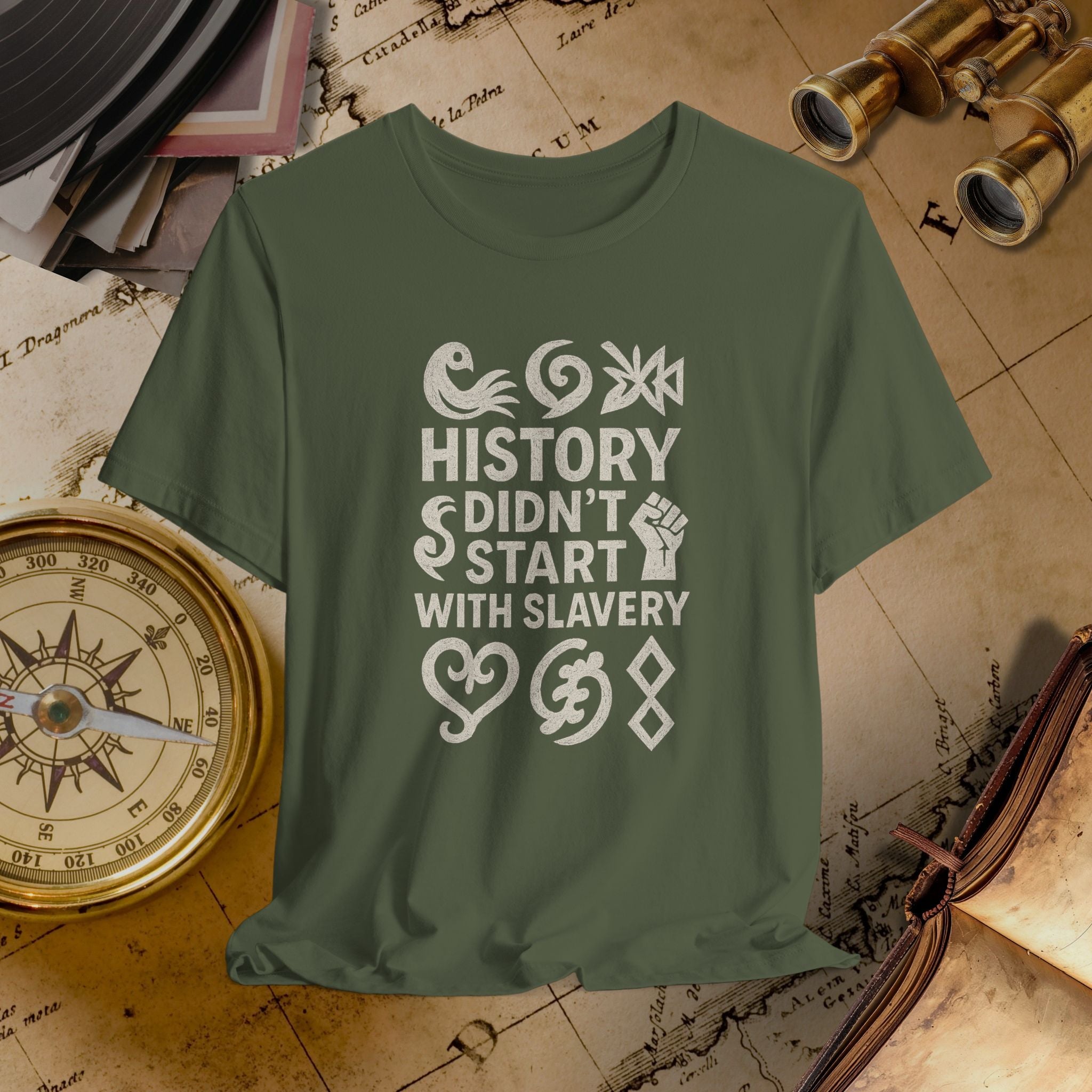 Green t-shirt with 'History didn't start with slavery' text on a vintage map background