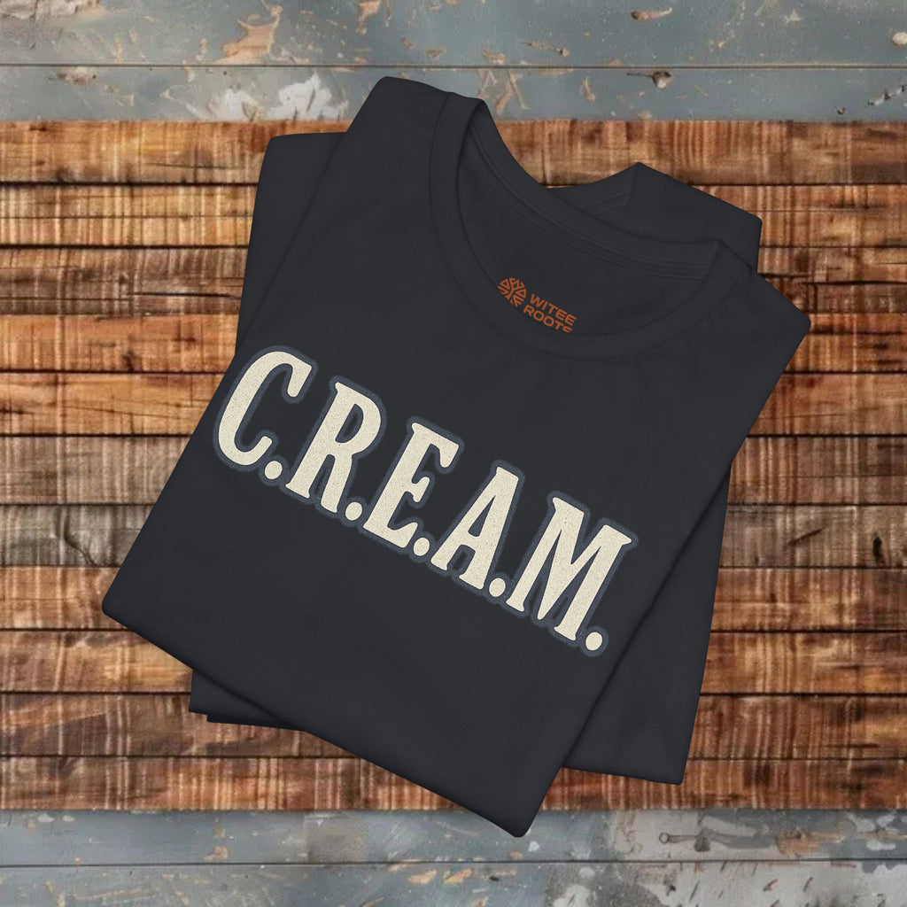 Black sweatshirt with 'C.R.E.A.M.' text on a wooden surface