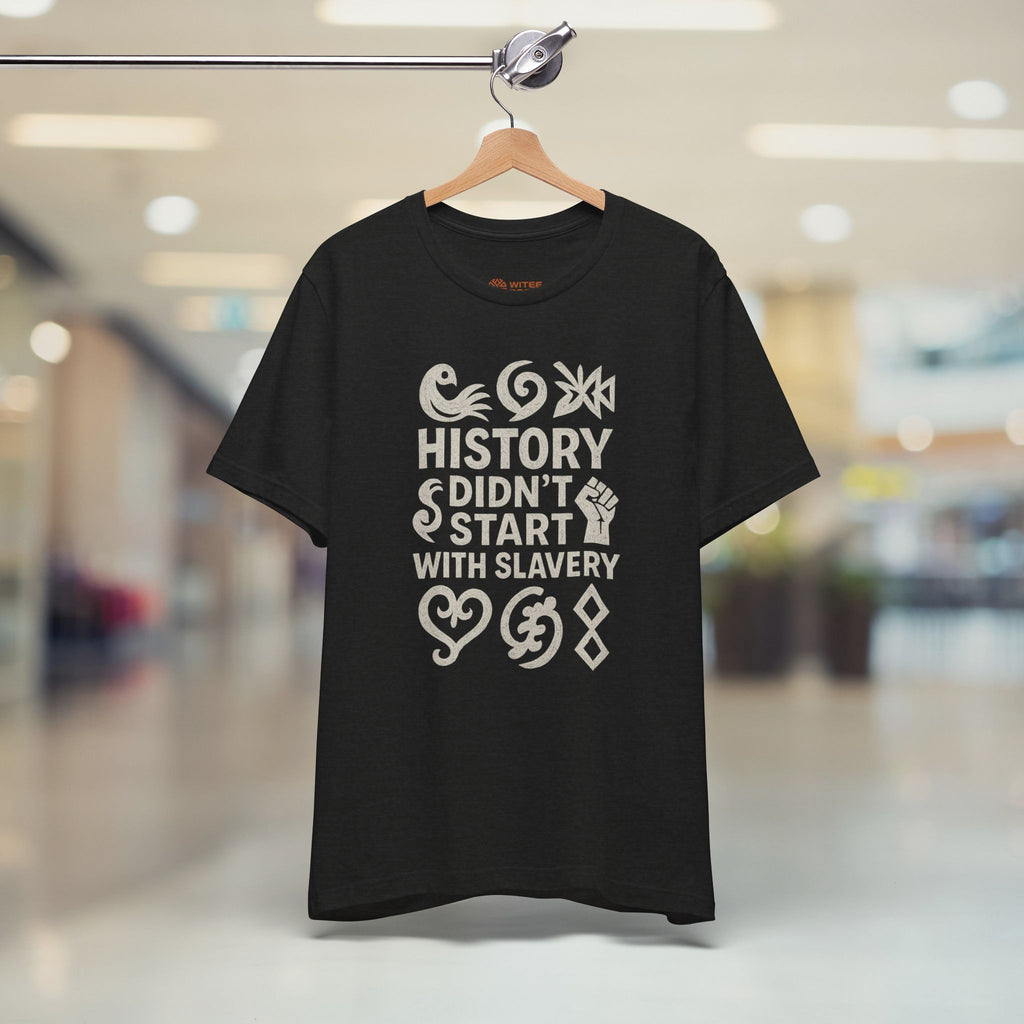 Black t-shirt with white text and graphics on a hanger in a store setting