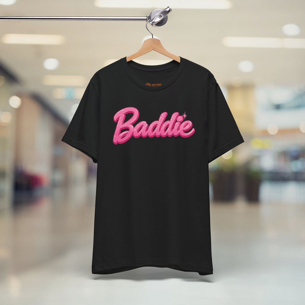 Black t-shirt with 'Diverse by Design' text on a hanger in a store.