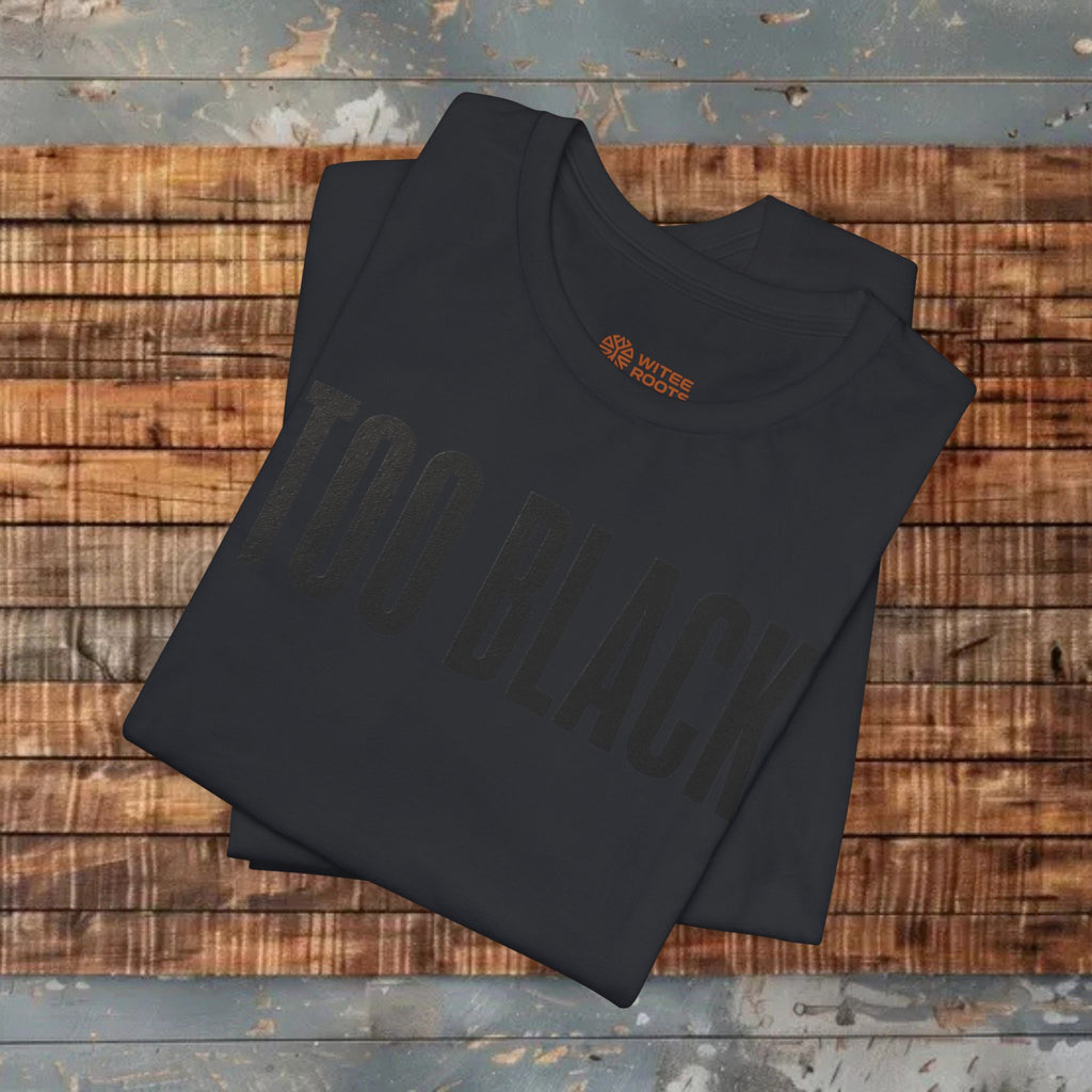 Folded black t-shirt with text and logo on a wooden surface