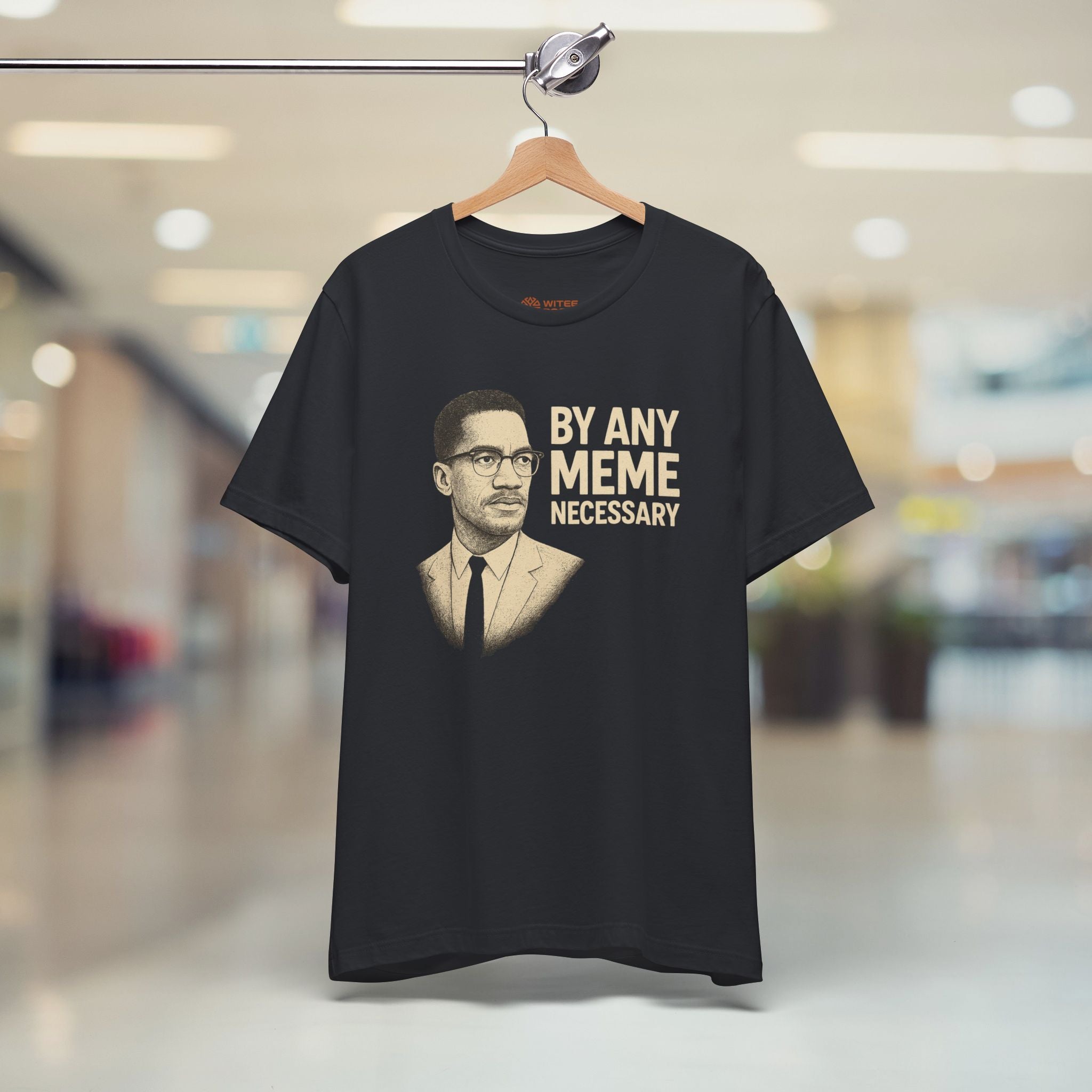 Black t-shirt with a graphic and text on a hanger in a store setting