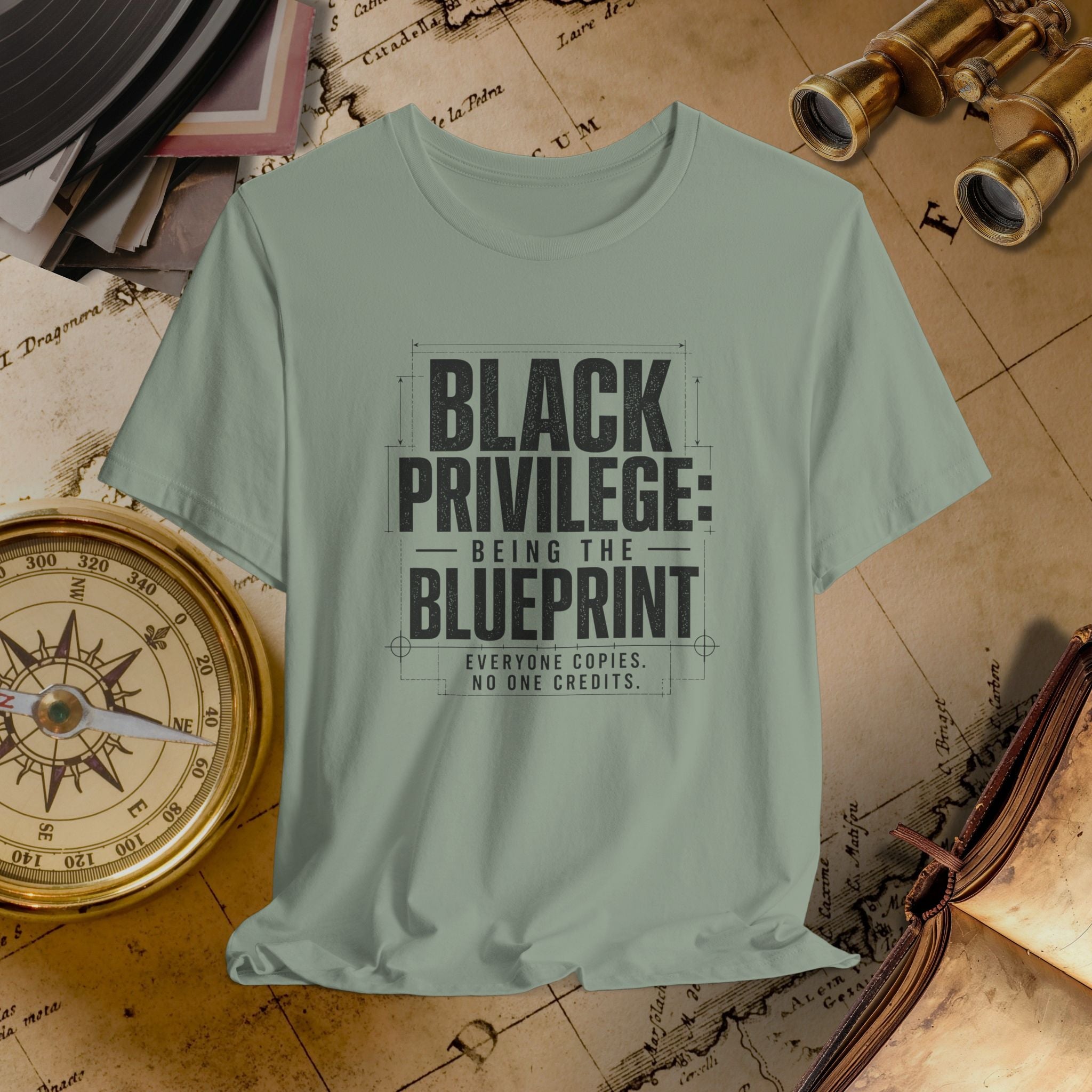 Light green t-shirt with 'Black Privilege: Being the Blueprint' text on a vintage map background.