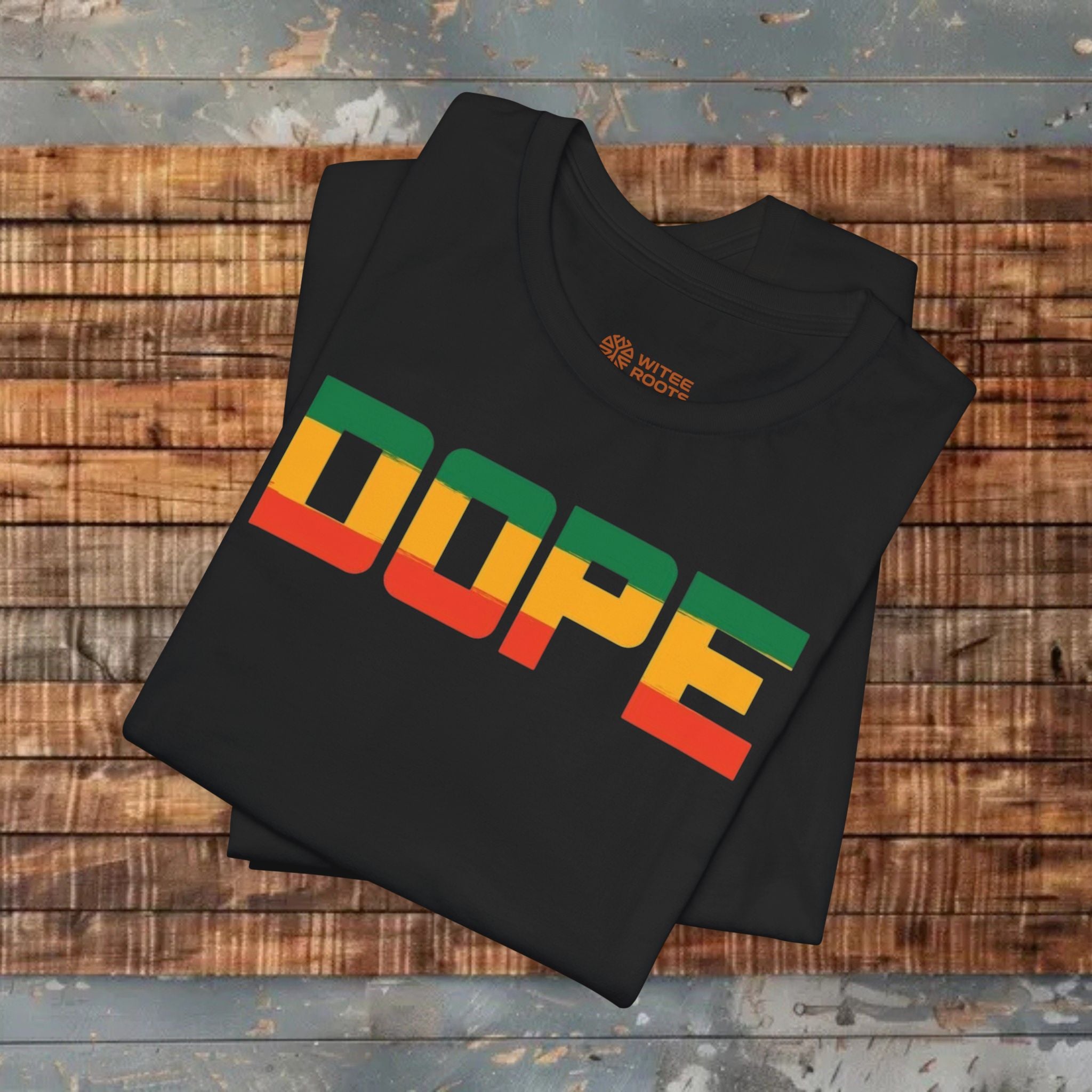 Black t-shirt with 'DOPE' in colorful letters on a wooden surface