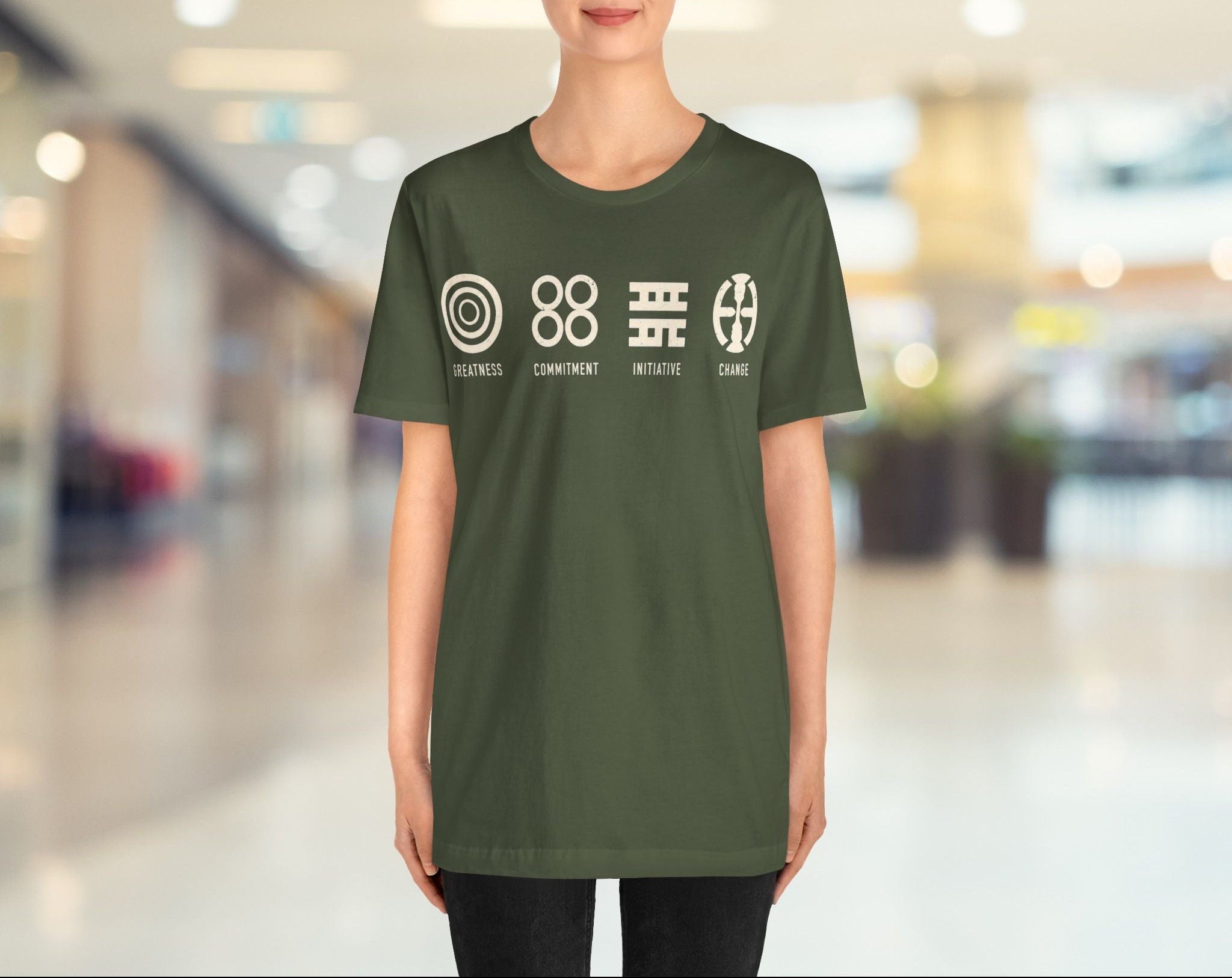 Person wearing a green t-shirt with symbols and text in an indoor setting