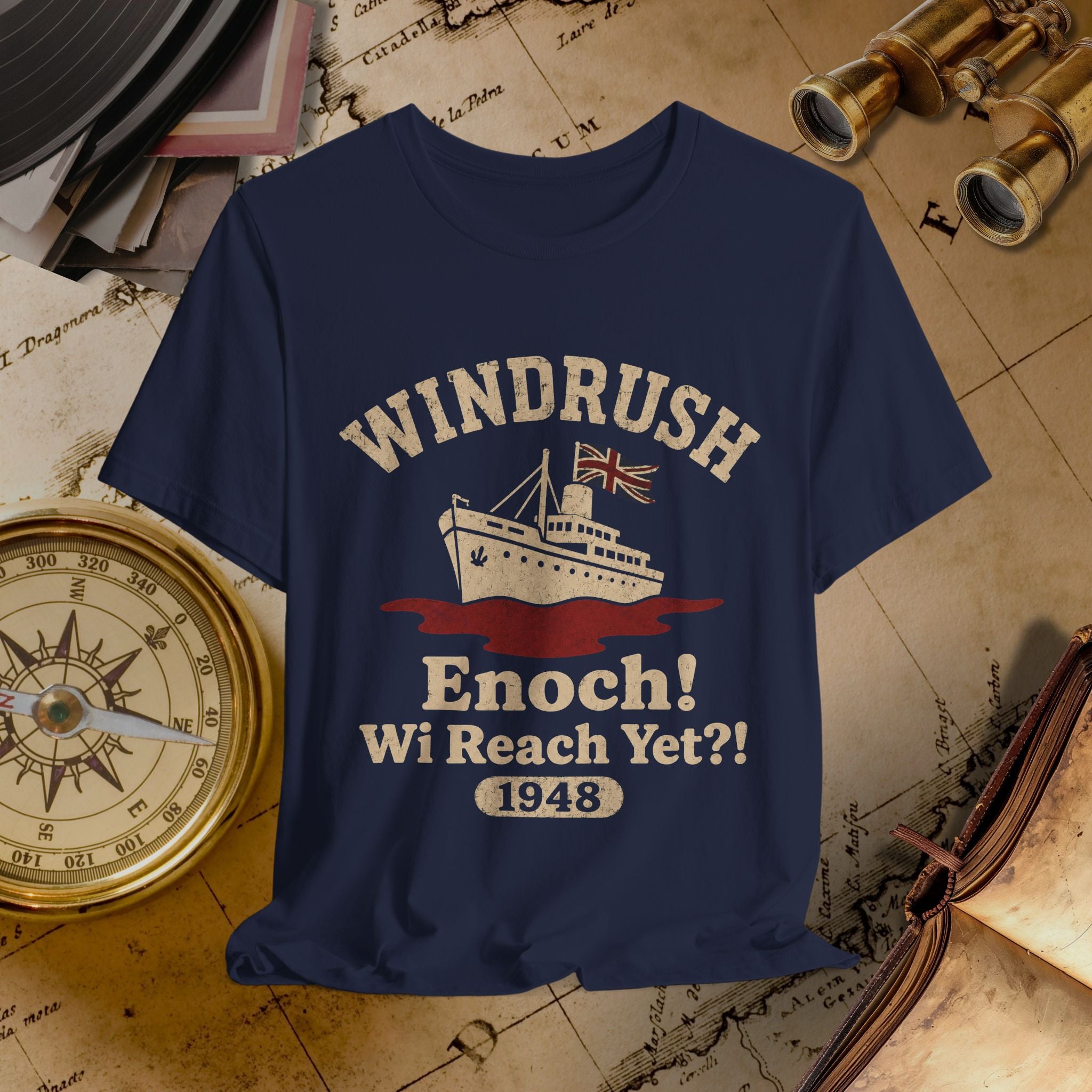 Navy blue t-shirt with 'Windrush Enoch! Wi Reach Yet?! 1948' design on a vintage map background.