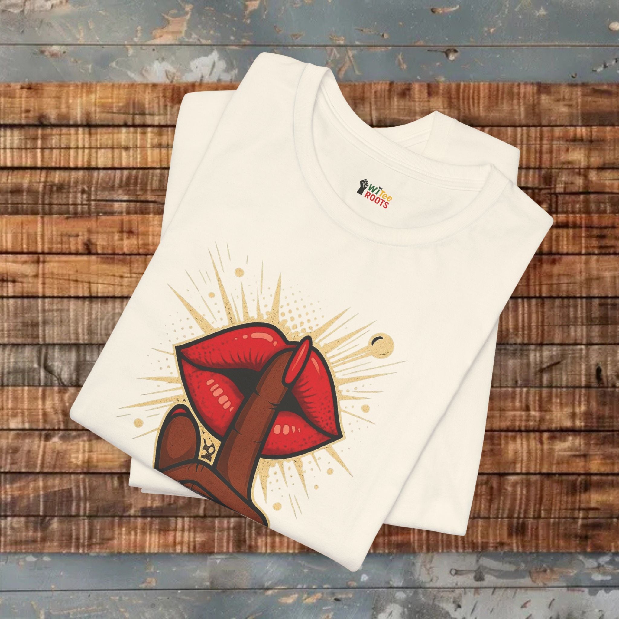 Beige t-shirt with red and brown graphic design on a wooden surface