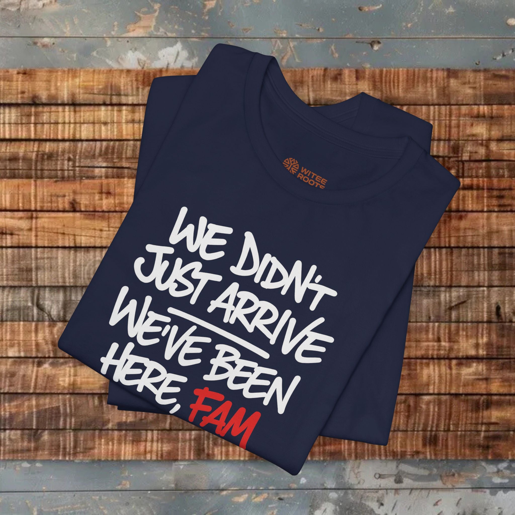 Folded navy blue t-shirt with text on a wooden surface