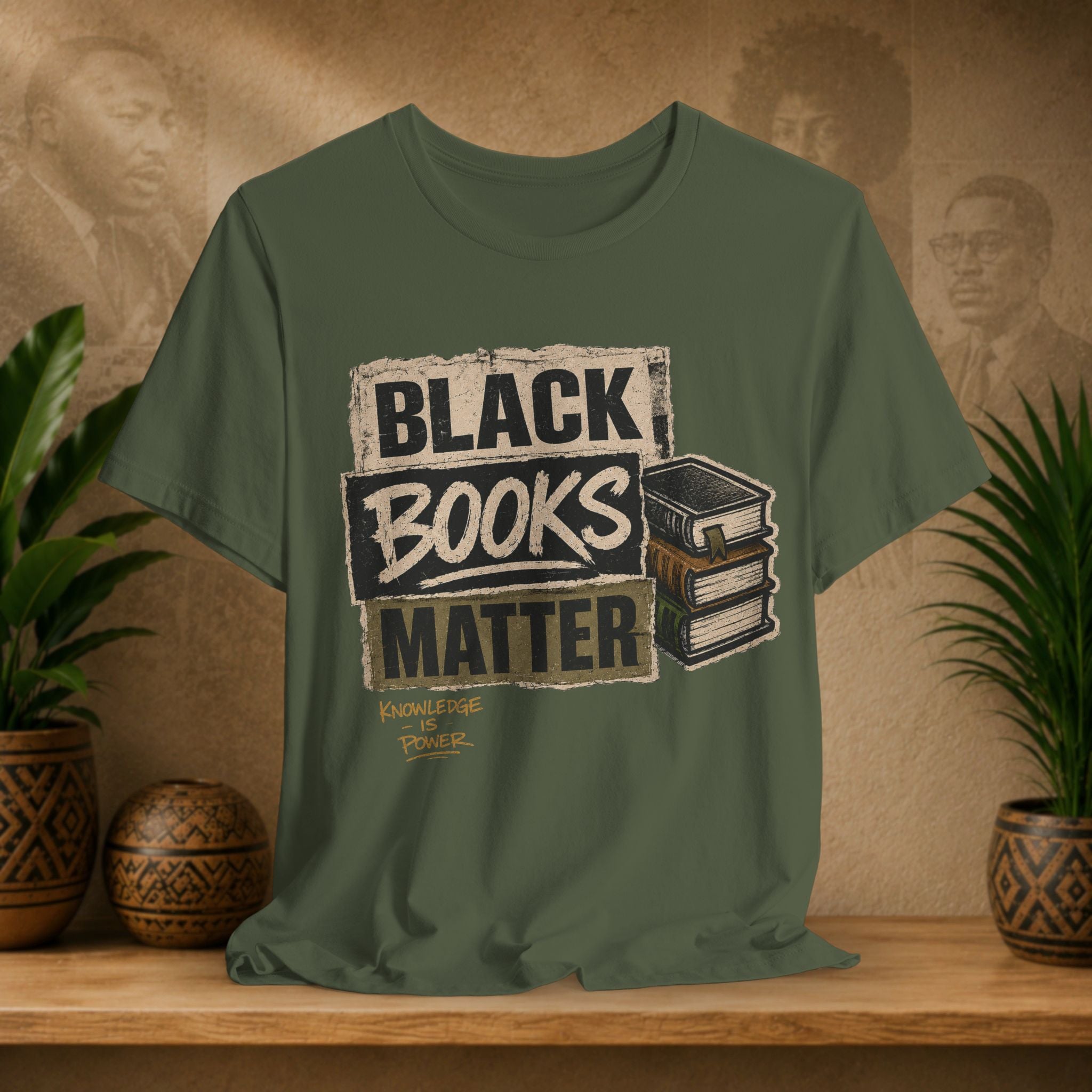 Green t-shirt with 'Black Books Matter' design on a wooden surface with plants and a textured wall background.