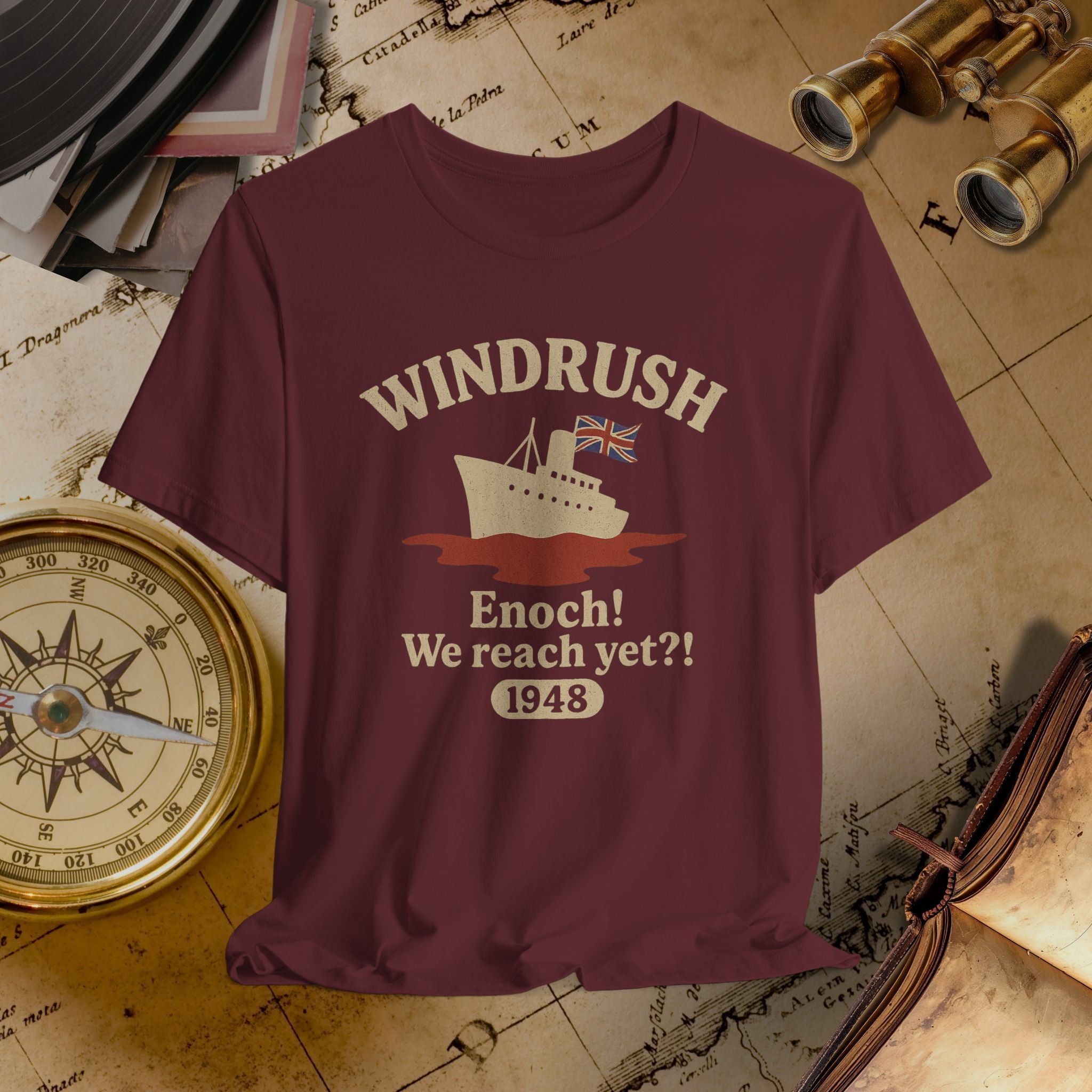 Maroon t-shirt with 'Windrush' design on a vintage map background