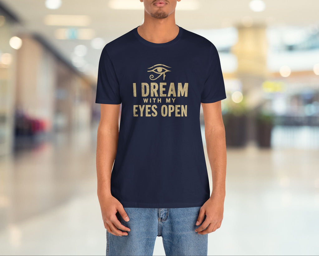Person wearing a navy blue t-shirt with gold text in a blurred indoor setting
