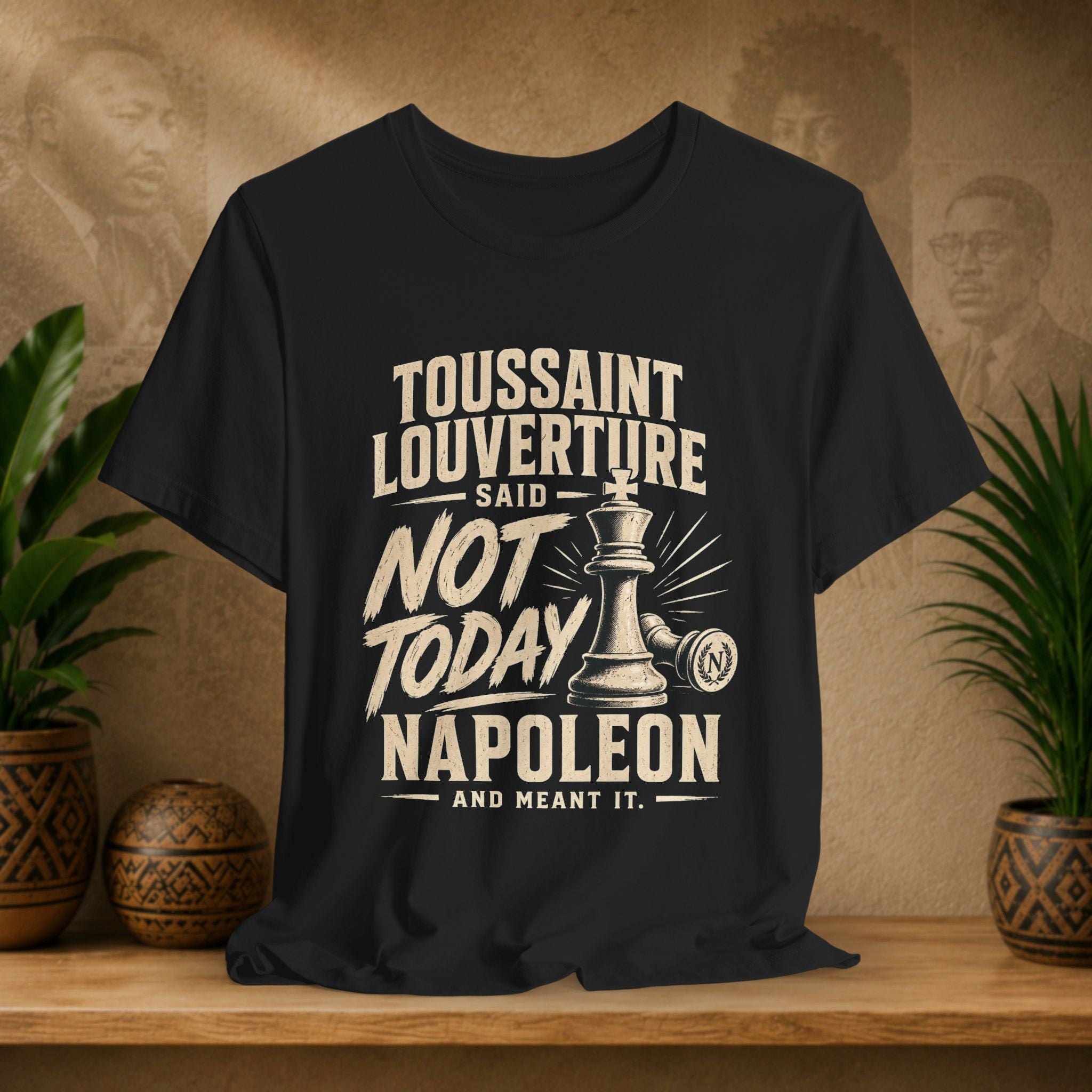 Black t-shirt with historical quote design on a wooden surface with plants and a blurred background
