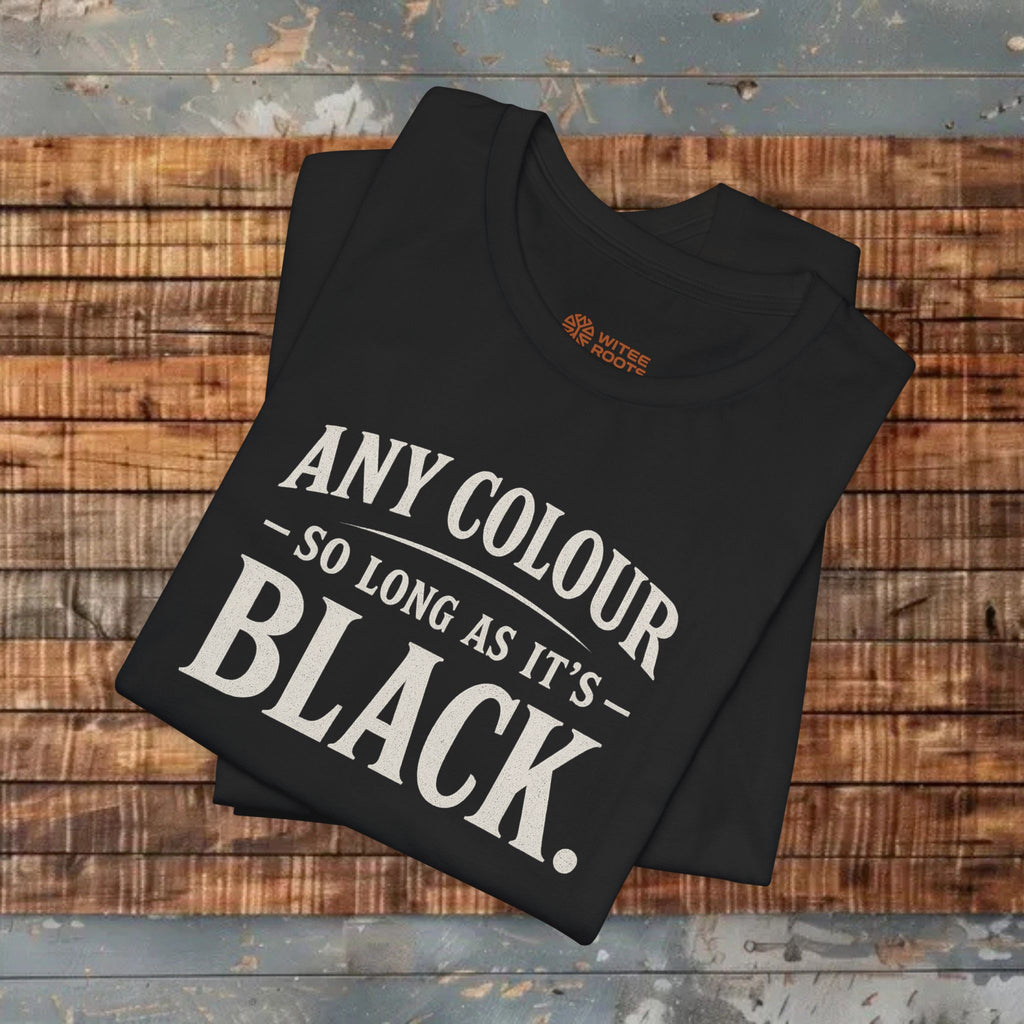 Folded black t-shirt with white text on a wooden surface