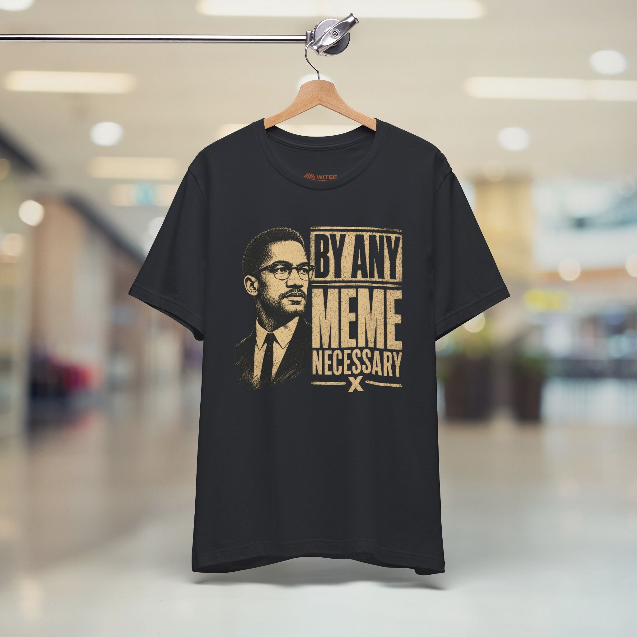Black t-shirt with graphic design and text on a hanger in a store setting