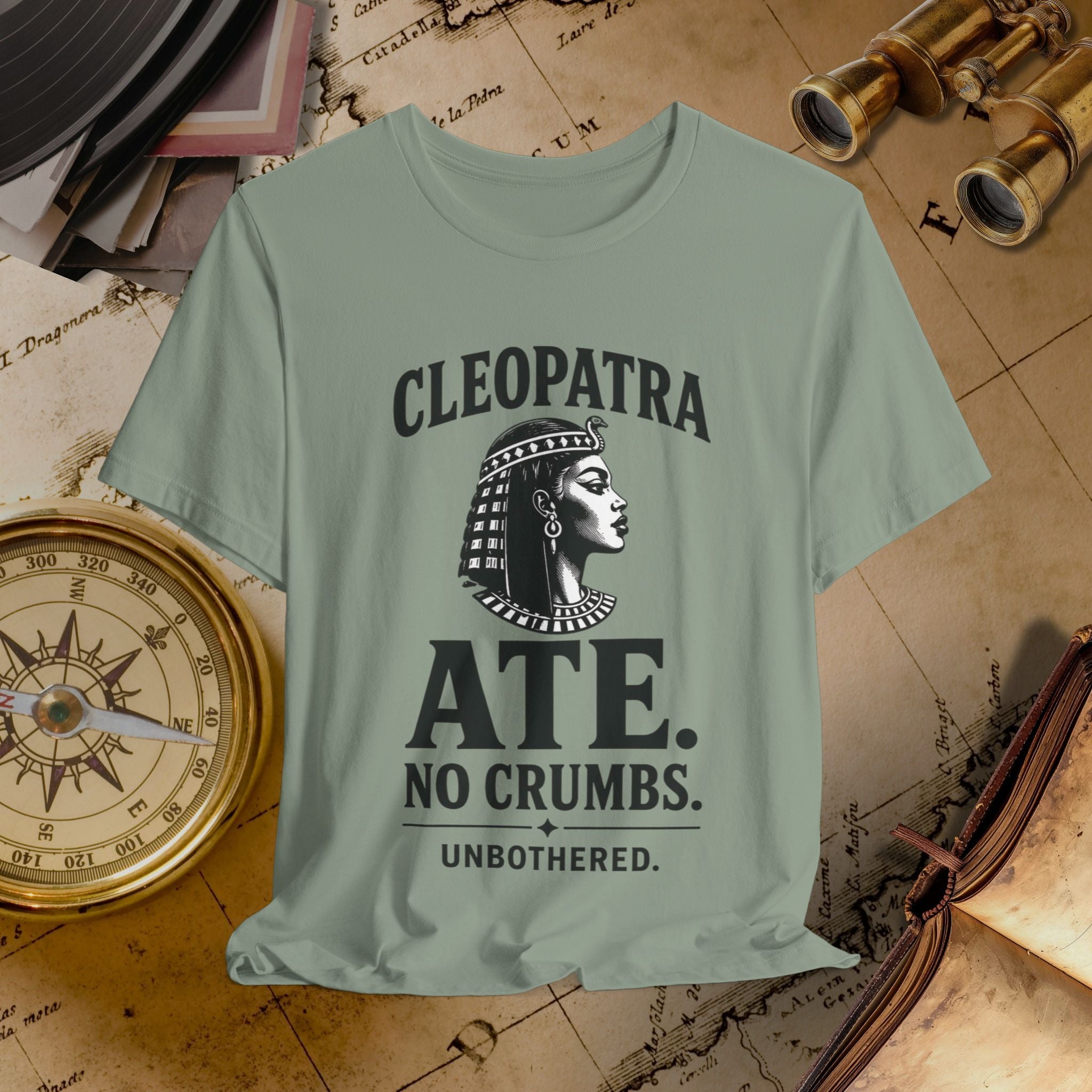 Light green t-shirt with Cleopatra graphic and text on a vintage map background
