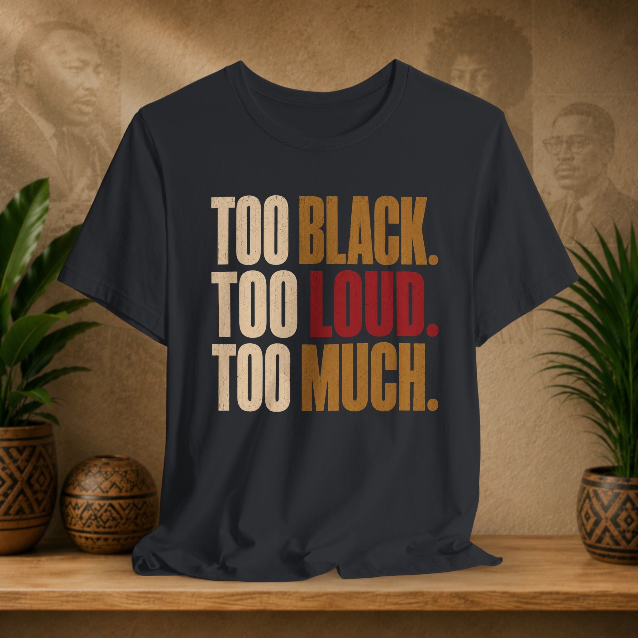 A black t-shirt with a bold text graphic reading 'TOO BLACK. TOO LOUD.