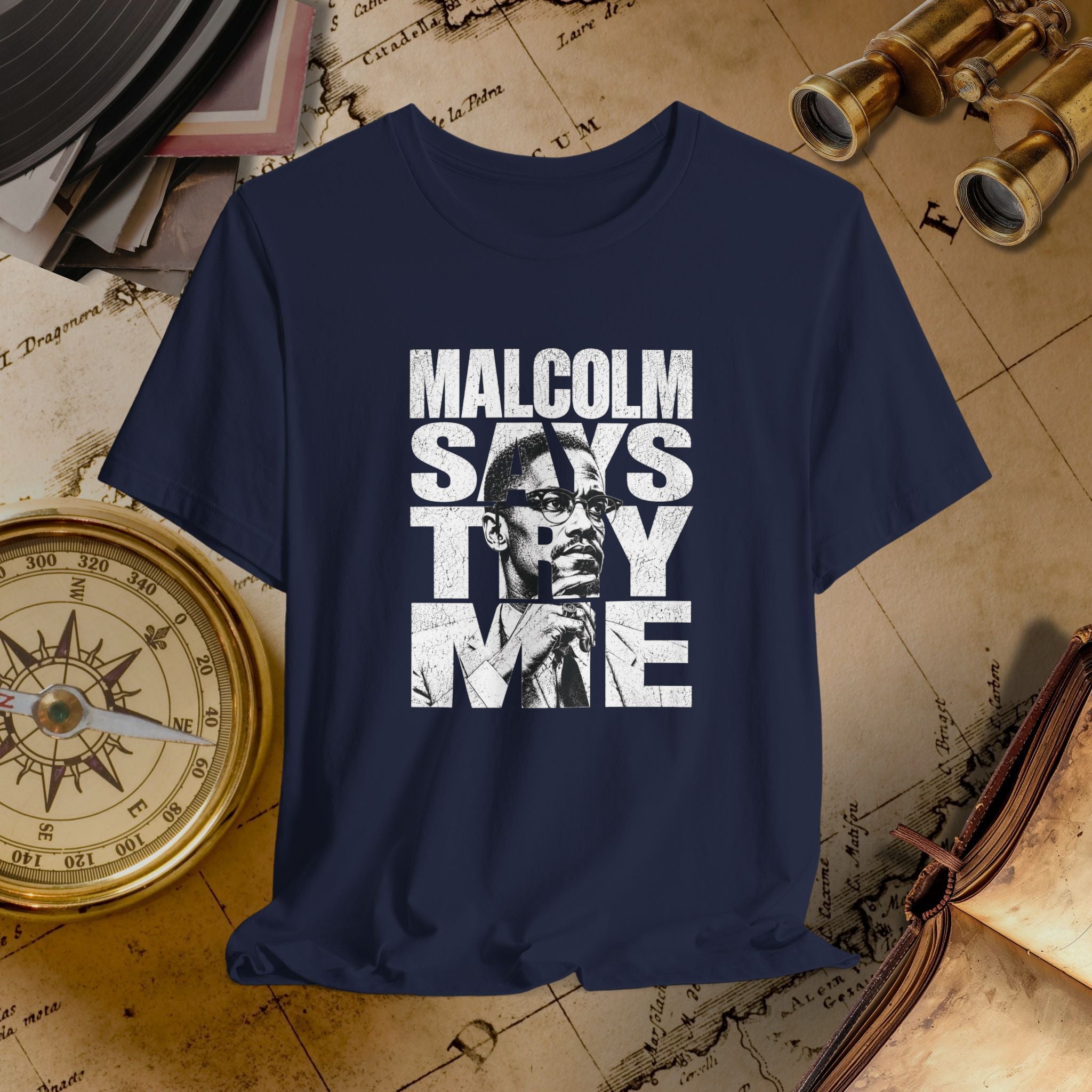 Navy blue t-shirt with 'Malcolm Says Thy Name' graphic on a vintage map background