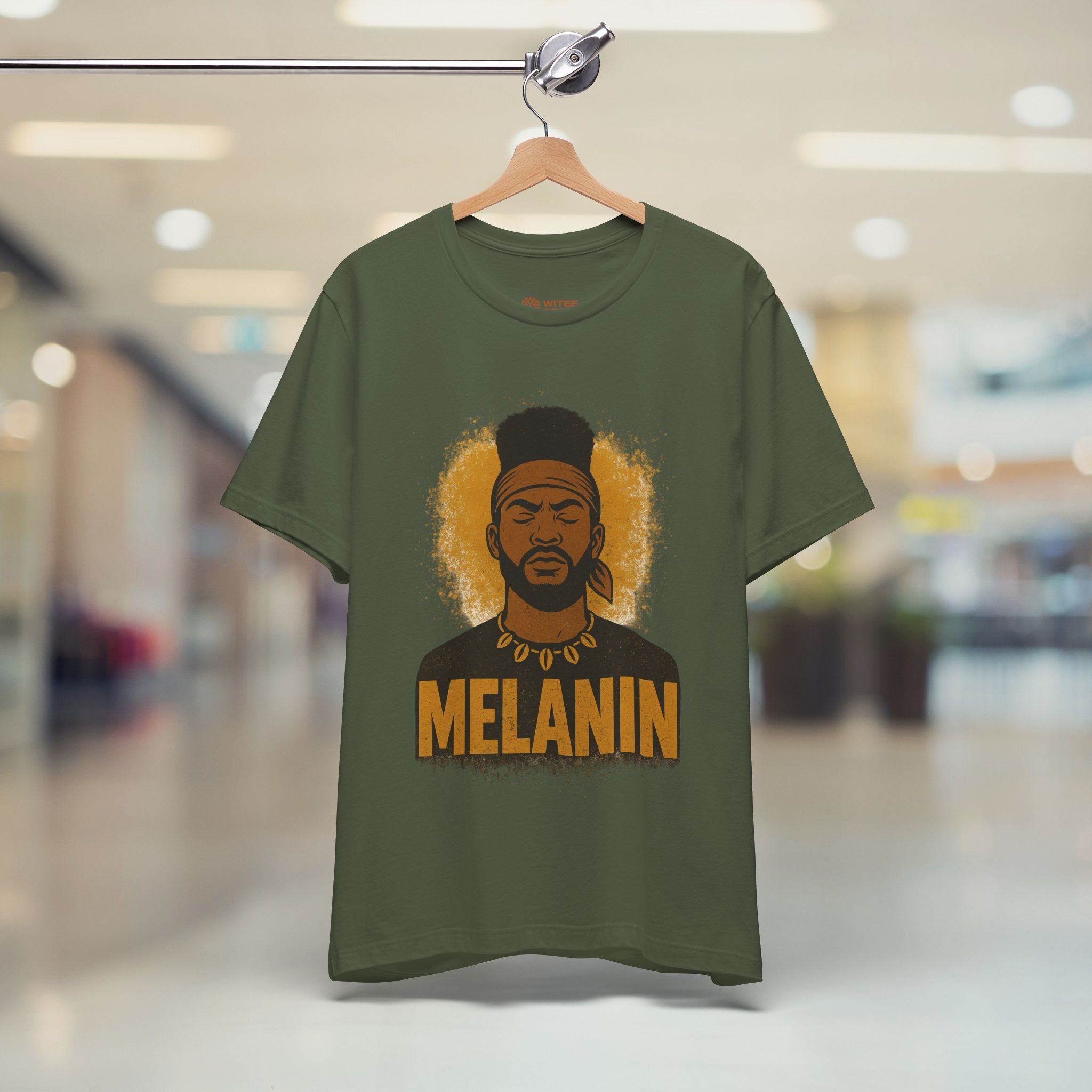 Green t-shirt with a graphic of a person and 'MELANIN' text on a hanger in a store.