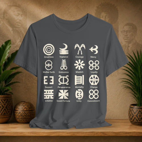 Gray t-shirt with white symbols and text on a wooden surface with plants and a textured wall background