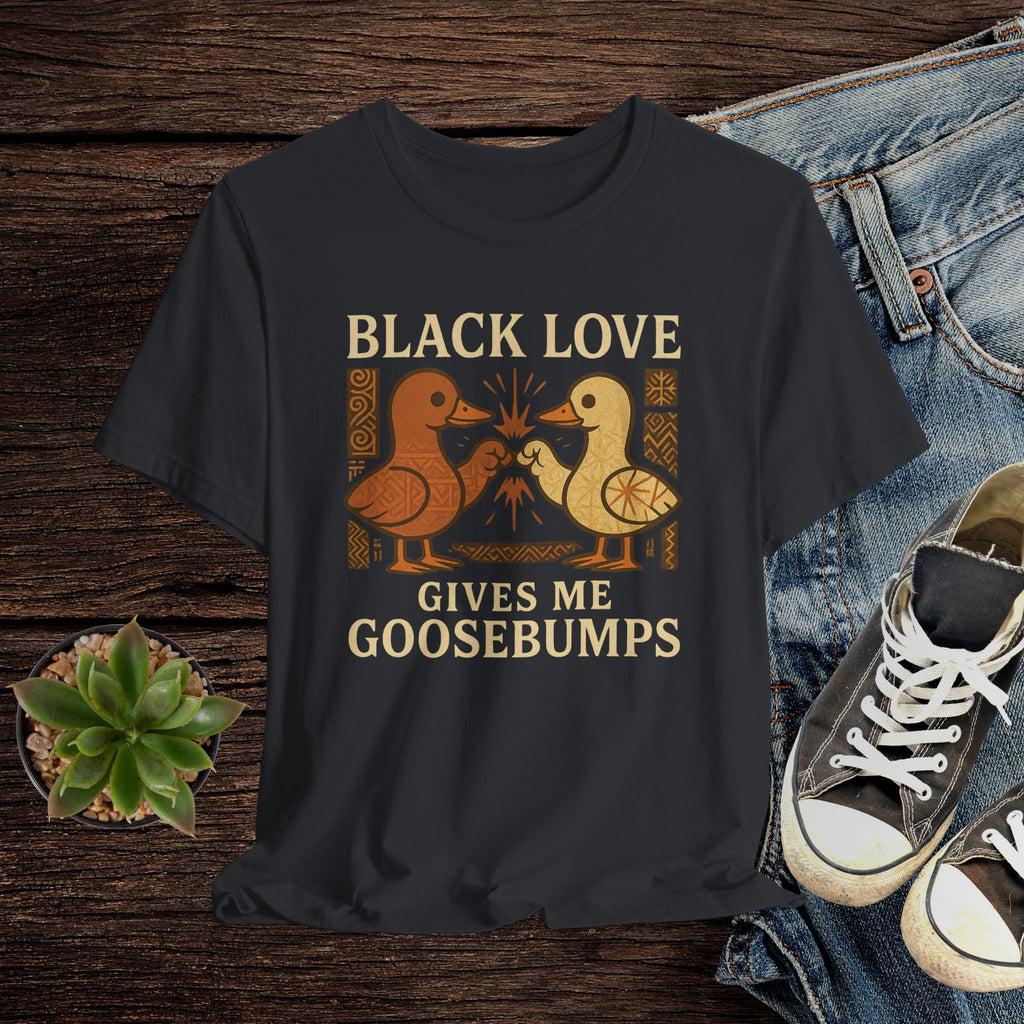 Black t-shirt with 'Black Love Gives Me Goosebumps' graphic on a wooden surface with jeans and sneakers.