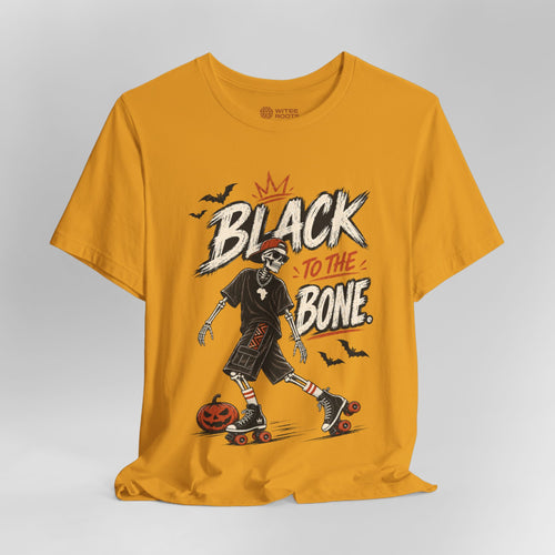 A mustard yellow graphic t-shirt featuring a skeleton roller skate character and the text 'BLACK TO THE BONE' with bats and a pumpkin, displayed on a neutral gray background.