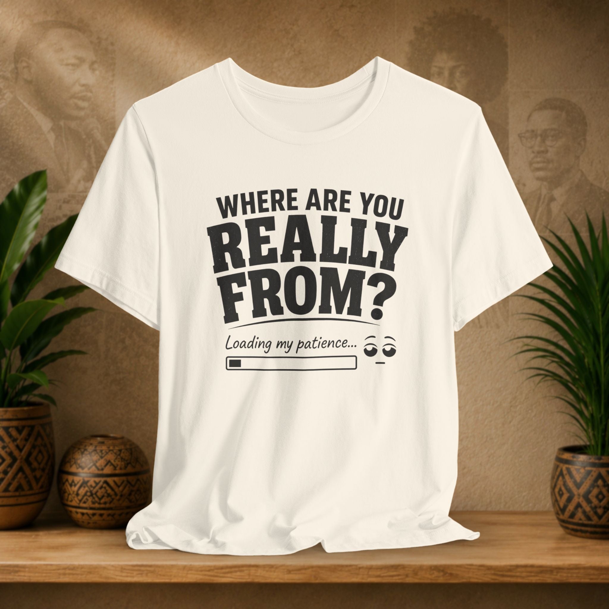 Beige t-shirt with humorous text design on a wooden surface with plants and a textured wall background