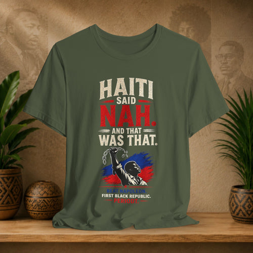 Green t-shirt with 'Haiti Said Nah And That Was That' design on a wooden surface with plants and decorative items.