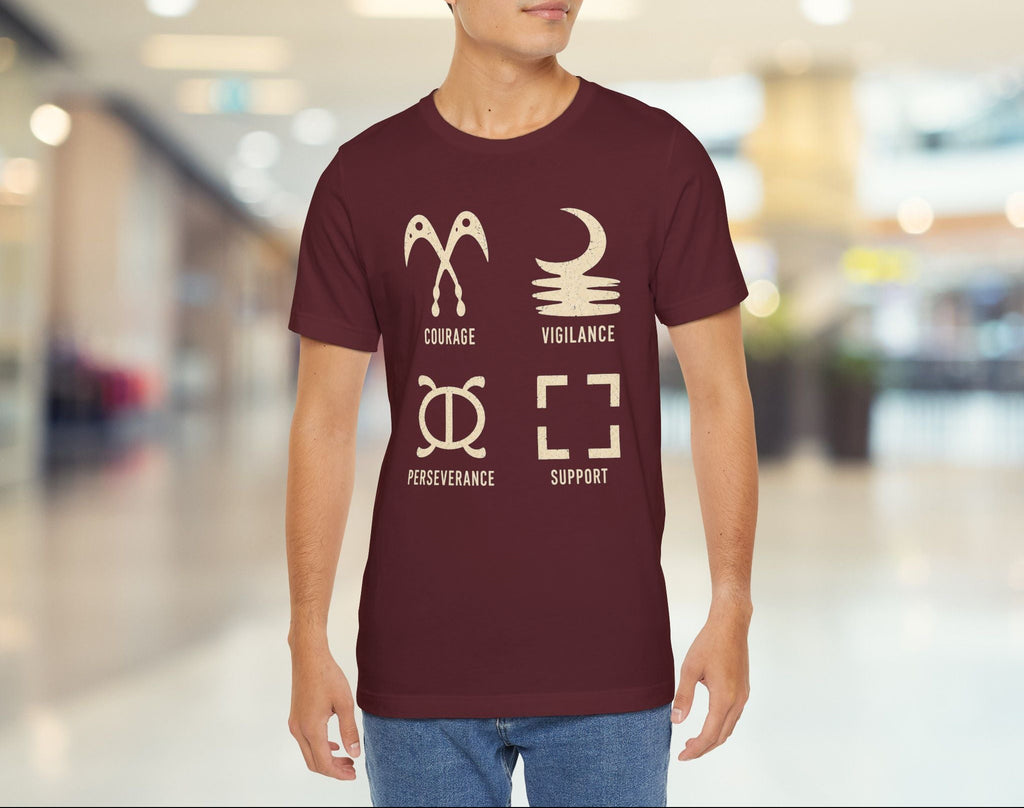 Man wearing a maroon t-shirt with motivational graphics and text in a blurred indoor setting