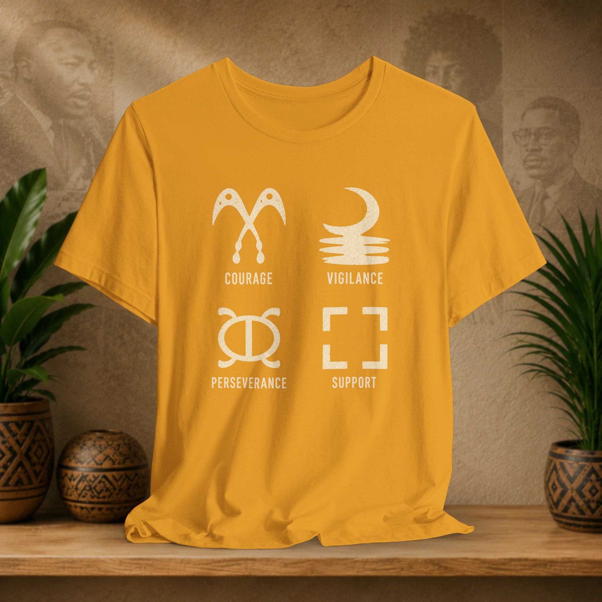 Yellow t-shirt with white symbols and text on a wooden surface with a decorative background