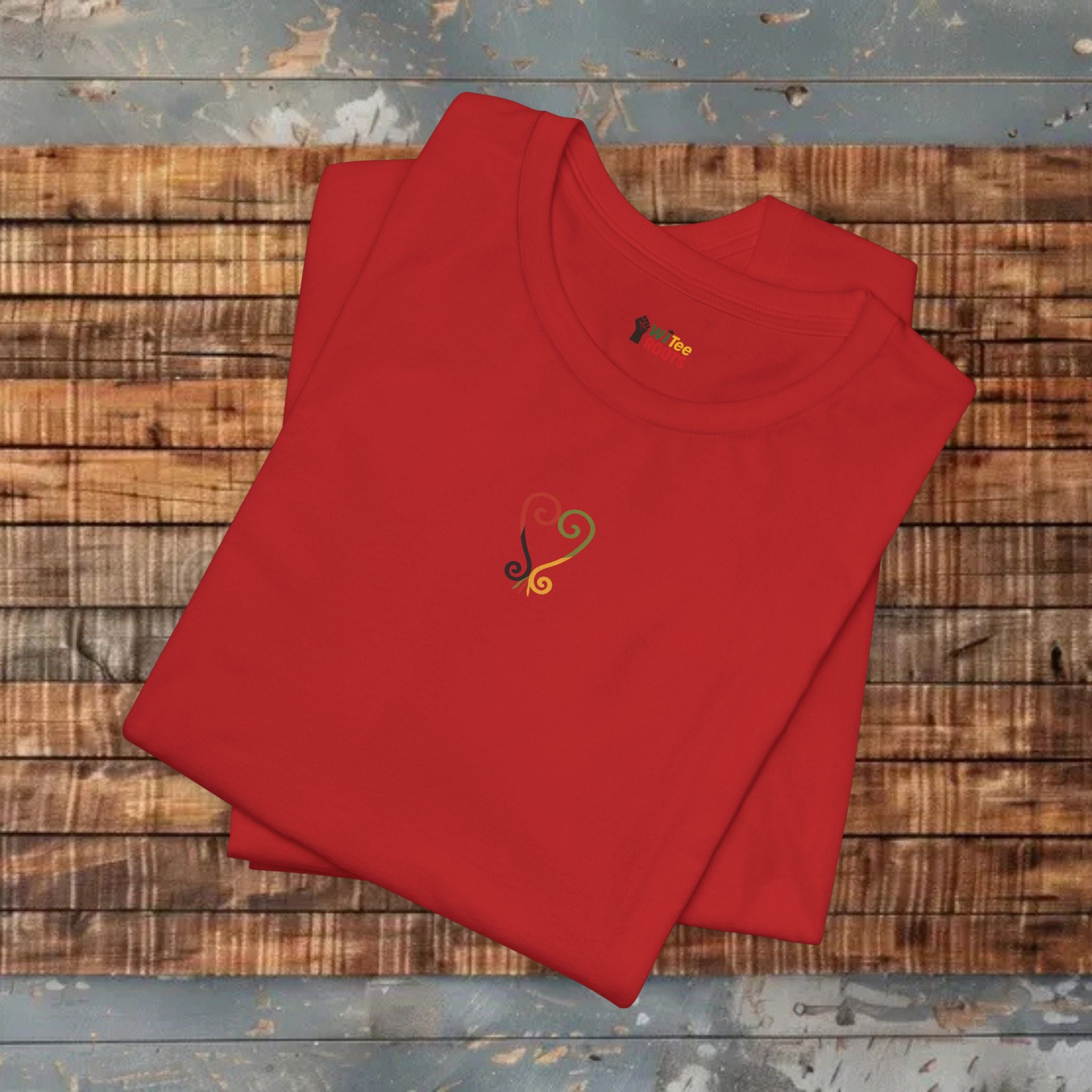 Folded red shirt with a heart design on a wooden surface