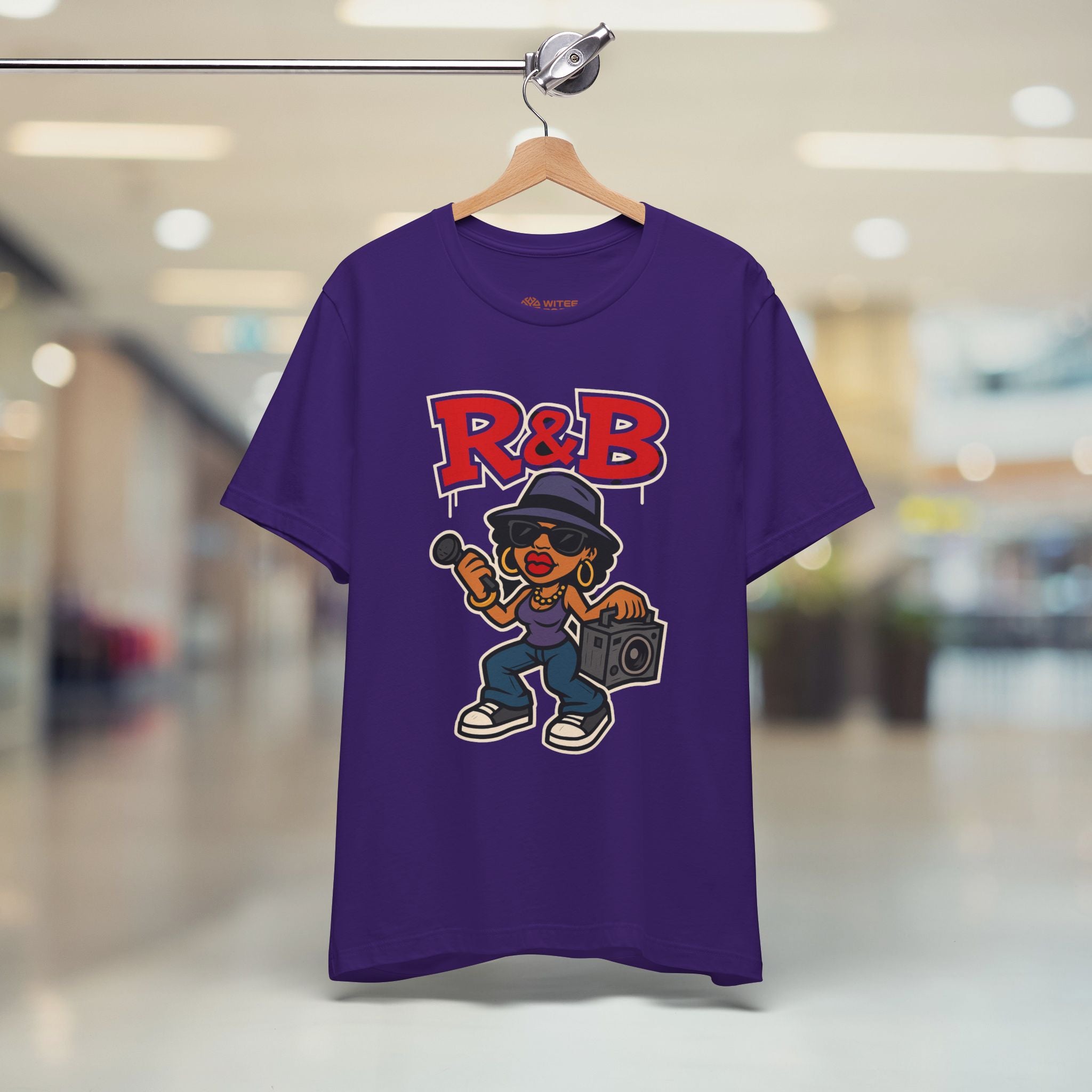 Purple t-shirt with 'R&B' design on a hanger in a store setting