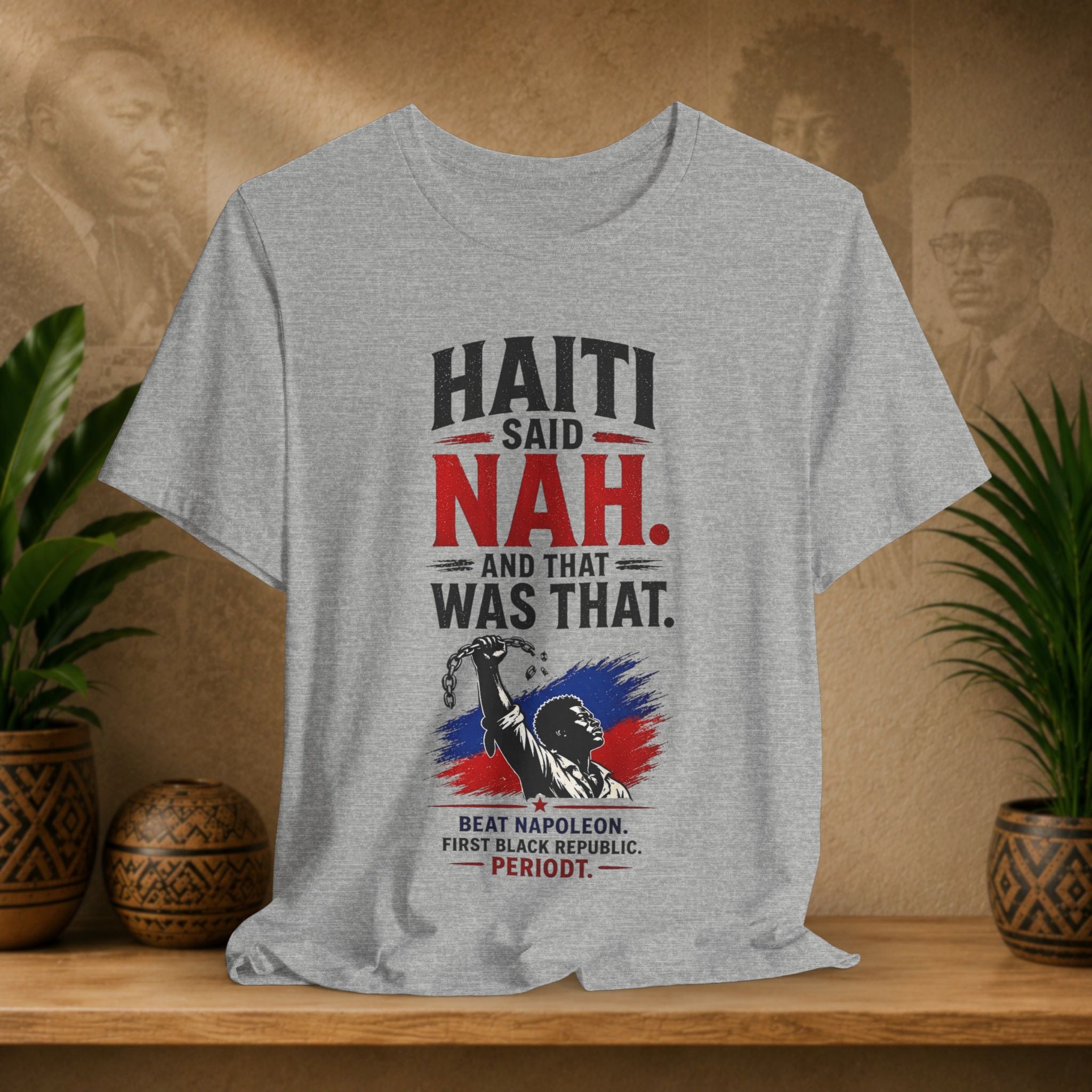 Gray t-shirt with political graphic design on a wooden shelf with plants and decorative items.