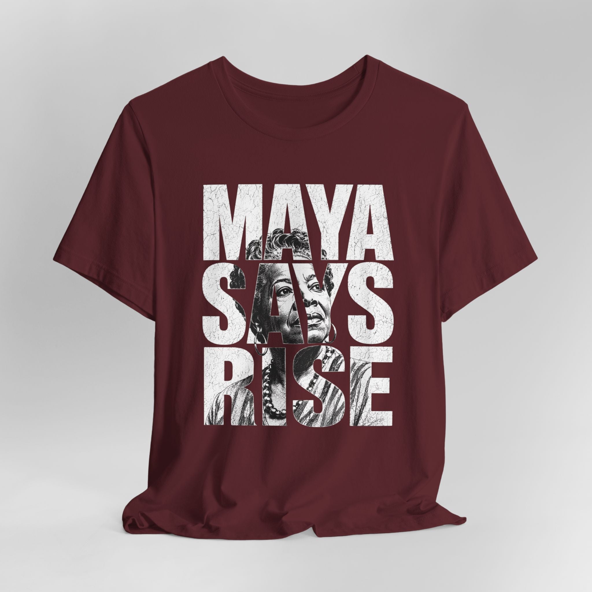 Maroon t-shirt with 'Maya Says Rise' text and graphic on a white background
