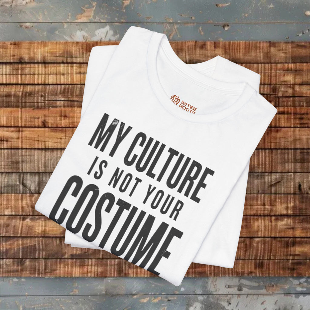 White t-shirt with 'My Culture is Not Your Costume' text on a wooden surface