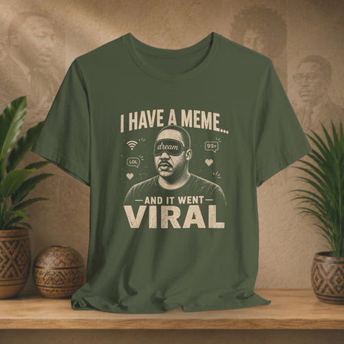 Green t-shirt with a graphic and text on a wooden surface with plants and a wall in the background